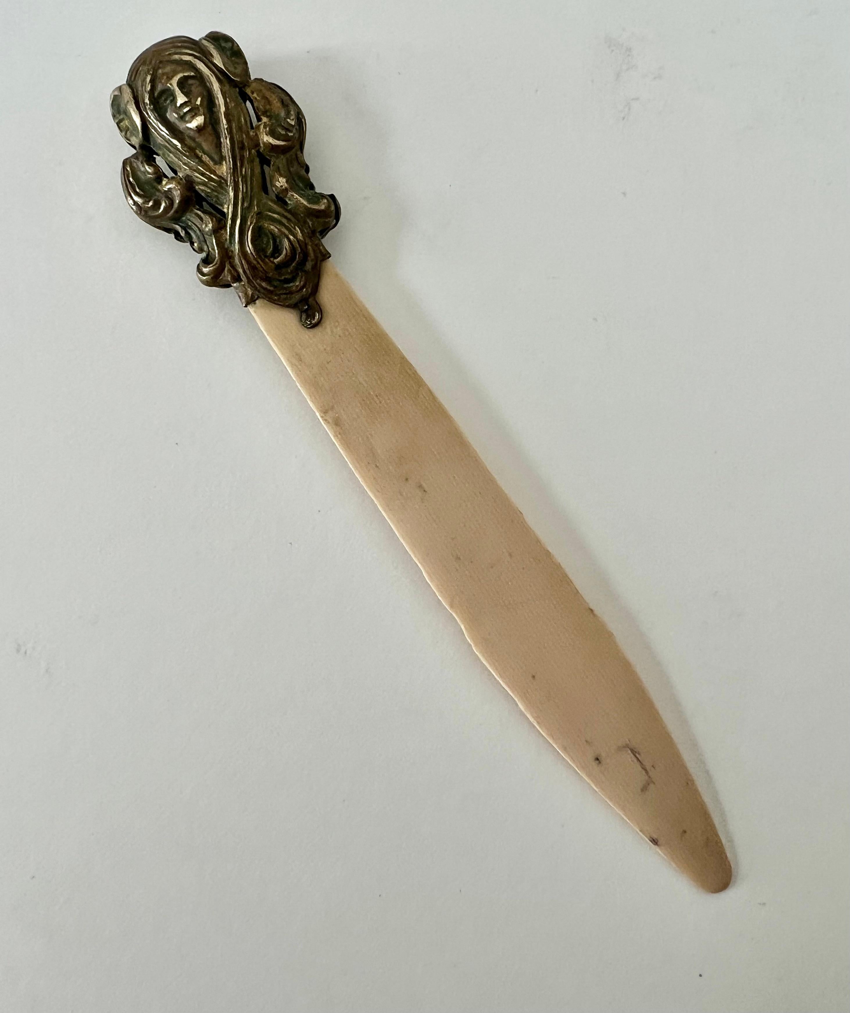 Acquired in Paris, this lovely Brass and bone art nouveau letter opener has a beautiful patina that will give your desk or work space a new sense of sophistication.  While the piece works, it is quite delicate, with a brass decorative top that is