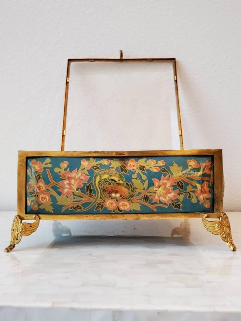 An exceptional Belle Époque period French artisan-crafted enameled jewel casket. Born in the late 19th century, having a square beveled and etched butterfly foliate motif hinged glass lid, patinated gilt metal frame, exquisite polychrome decoration,