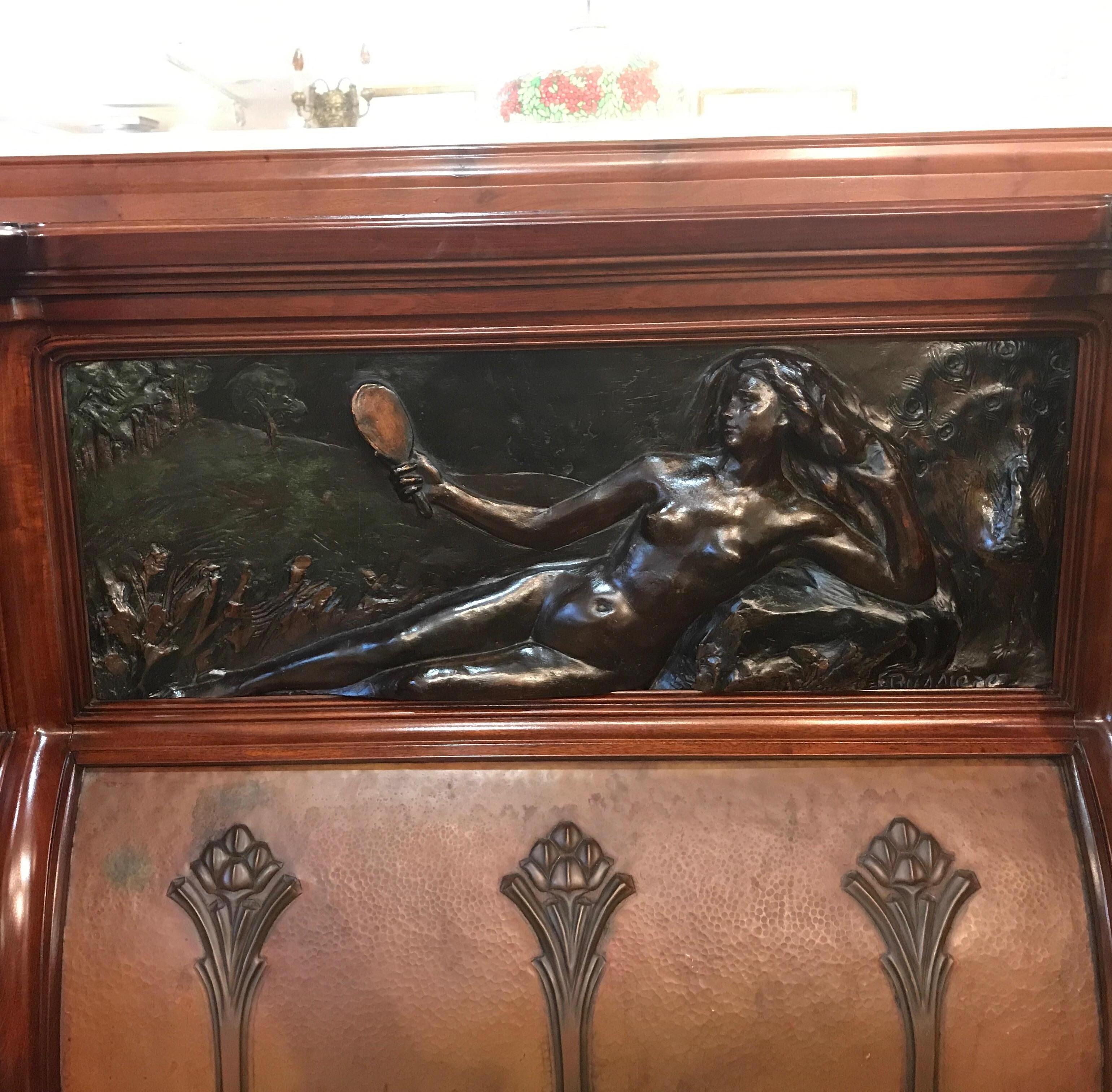 An of the period Art Nouveau hand carve fireplace mantel with over mantel mirror. The lavishly carves sides with a hand-carved poly-chromed panel depicting a female nude with hand mirror. The surround in the centre is hand-hammered copper. Marked on
