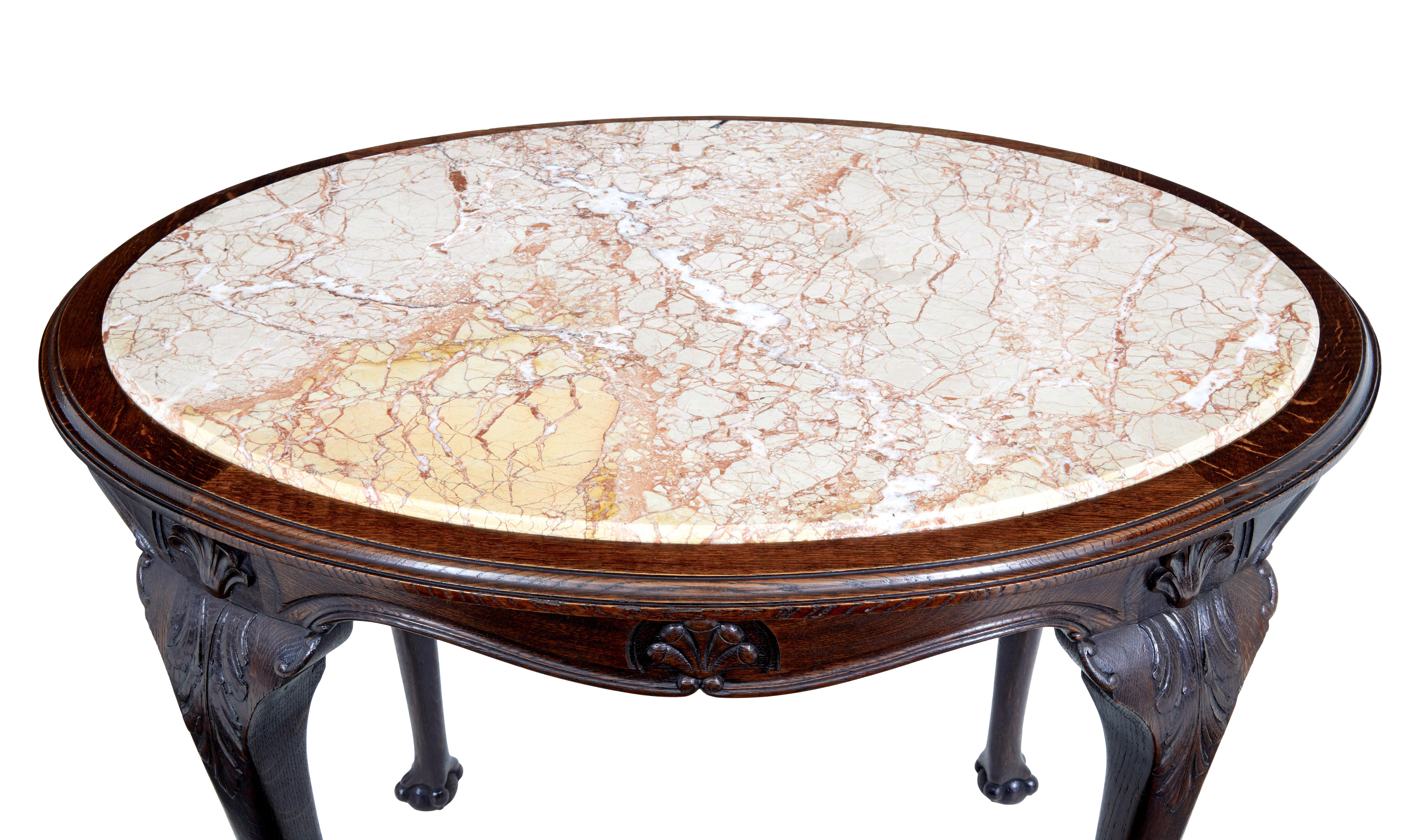 19th century French oak marble top center table, circa 1880.

Art Nouveau oak center table, stunning inset veined marble top with carved shells to the apron. Standing on 4 cabriole legs with further shells and carved leaves. Terminating on a ball