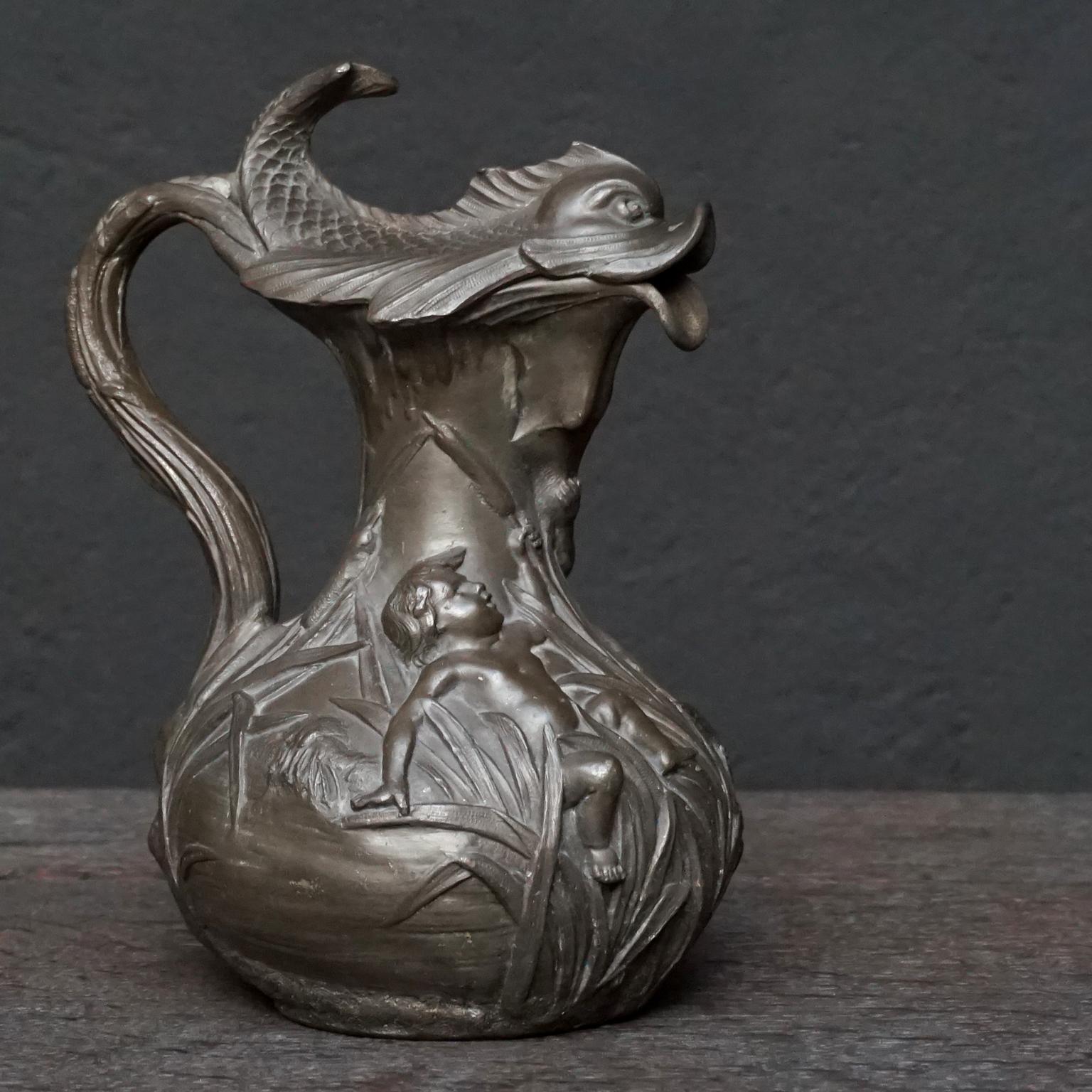 Beautiful heavy Art Nouveau pewter pitcher with charming scene of boys or putti playing in the riverside reed catching a fish, signed H. Huppe. This jug or pitcher dates somewhere between 1878-1904 when Huppe exhibited regularly at the Expo des