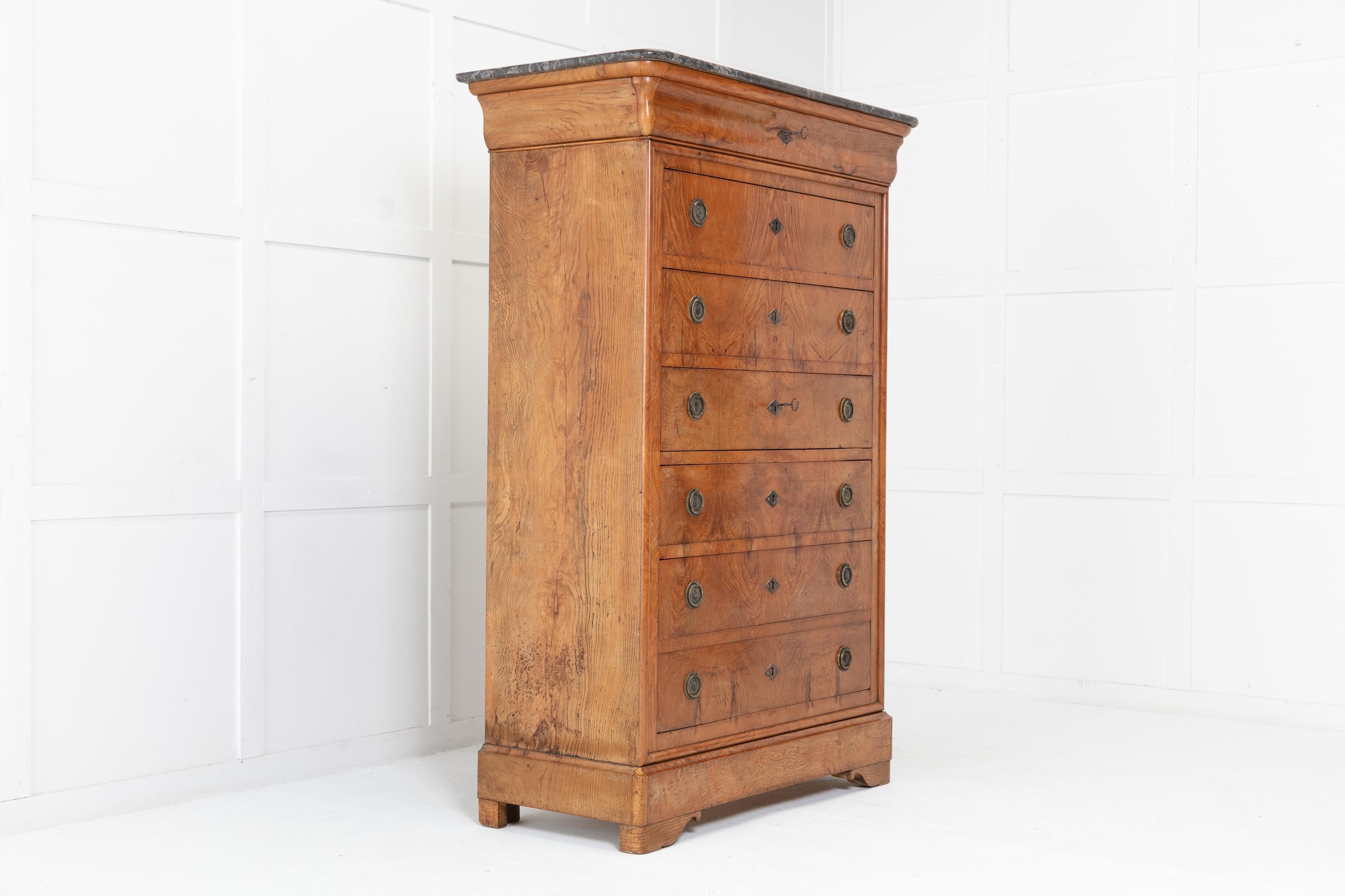 A tall 19th century French ash semainier with secre´taire drawer and original grey and white veined marble top. The top moulded cornice has a long and shaped drawer with lock and key. Below are a further six drawers with brass handles. The middle
