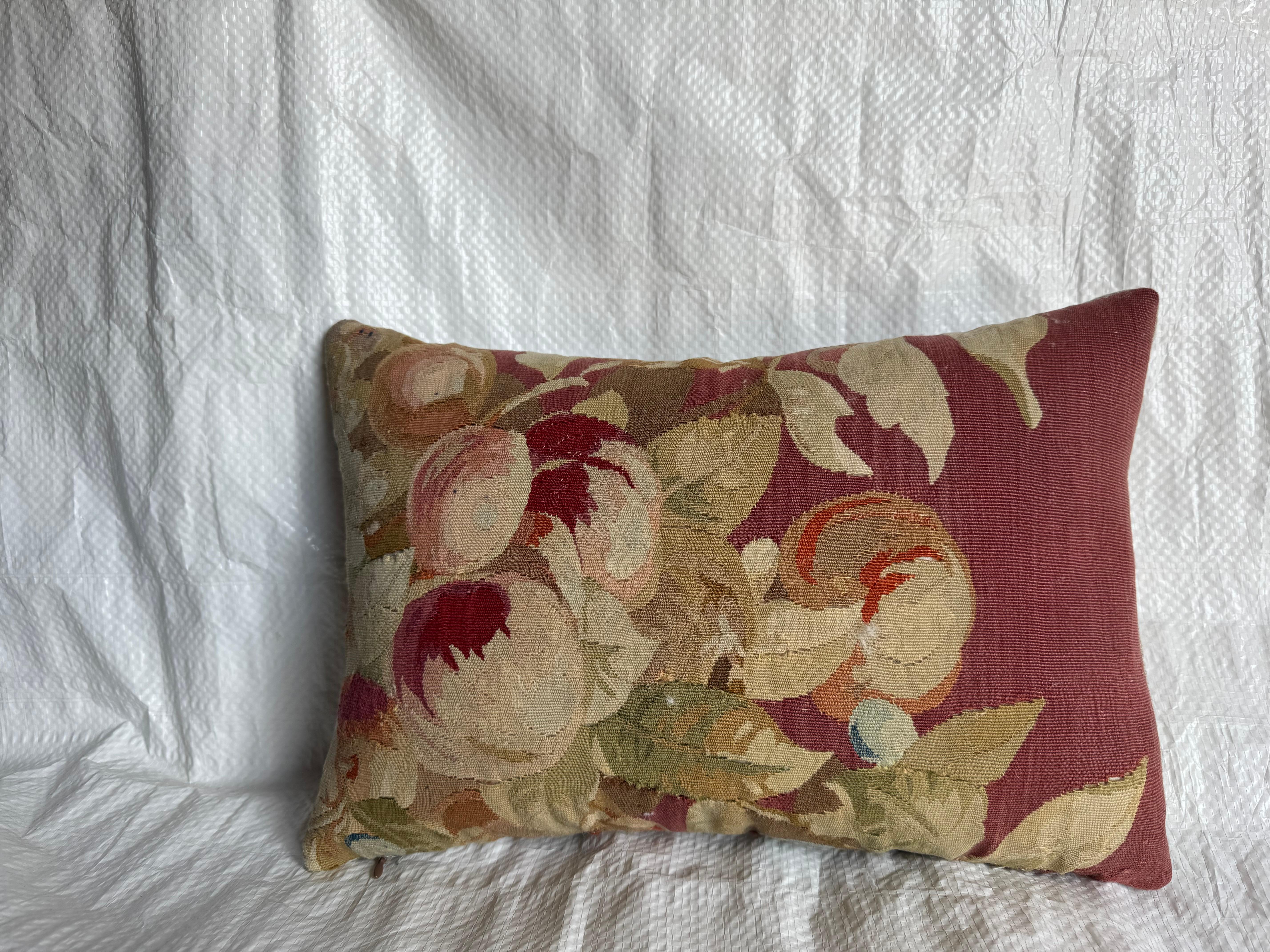 Questo cuscino è ricavato da un frammento originale di arazzo di Aubusson della metà del XIX secolo, risalente al 1850 circa. Il disegno raffigura un bouquet di fiori nei toni del crema, del blush, del verde e del rosso, intrecciati su un fondo