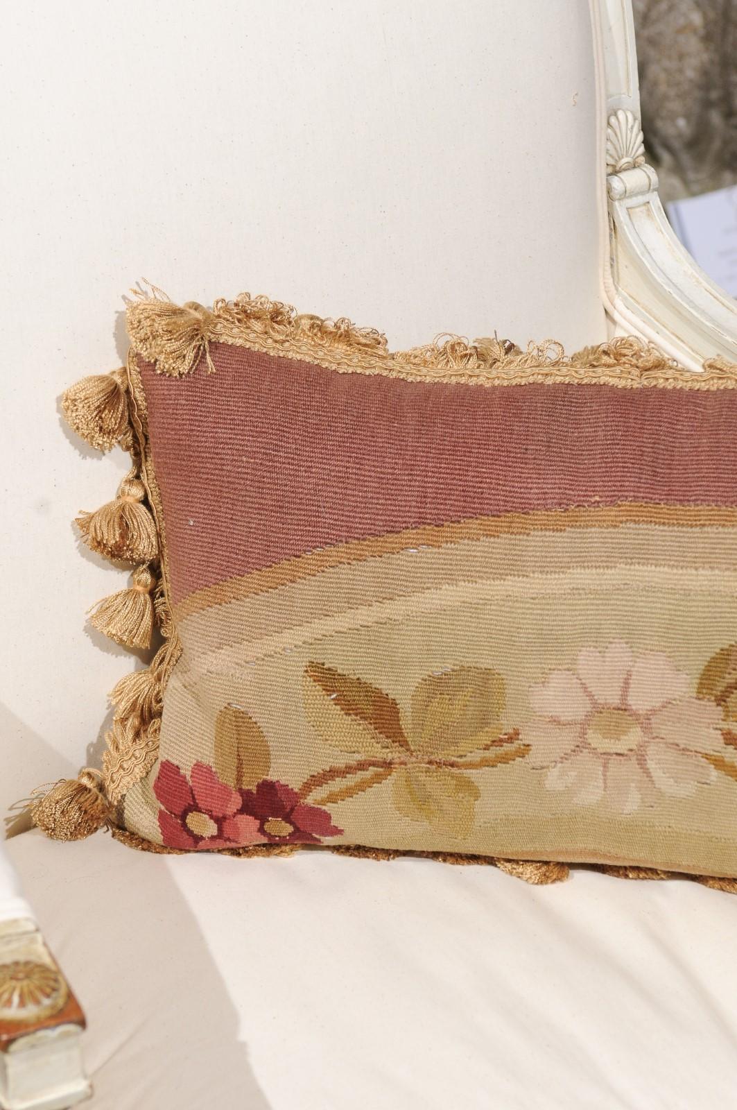 Cuscino francese con arazzo Aubusson del XIX secolo, con decorazioni floreali e piccole nappe. Creato nella manifattura di arazzi di Aubusson, nella Francia centrale, durante il XIX secolo, questo cuscino orizzontale è caratterizzato da fiori
