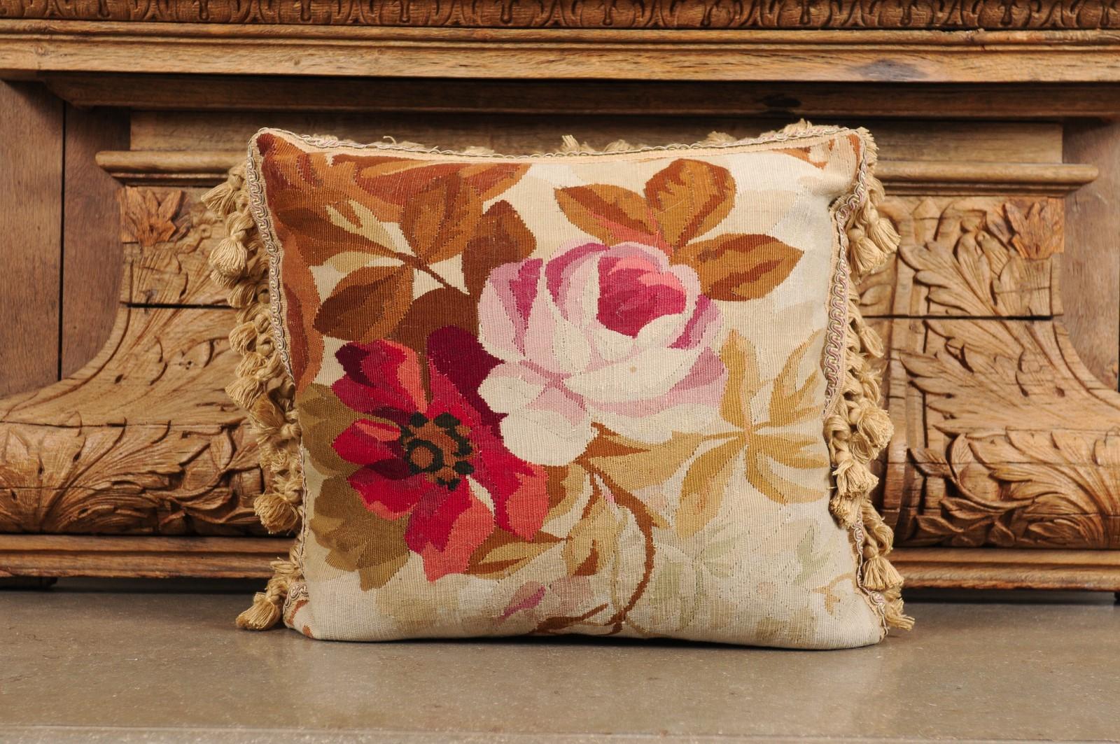 Ein französisches Aubusson-Kissen aus dem 19. Jahrhundert, mit Blumendekor und Troddeln. Dieses Kissen, das im 19. Jahrhundert in der Gobelinmanufaktur Aubusson in Zentralfrankreich hergestellt wurde, zeigt eine rosafarbene Rose und eine rote Blume,