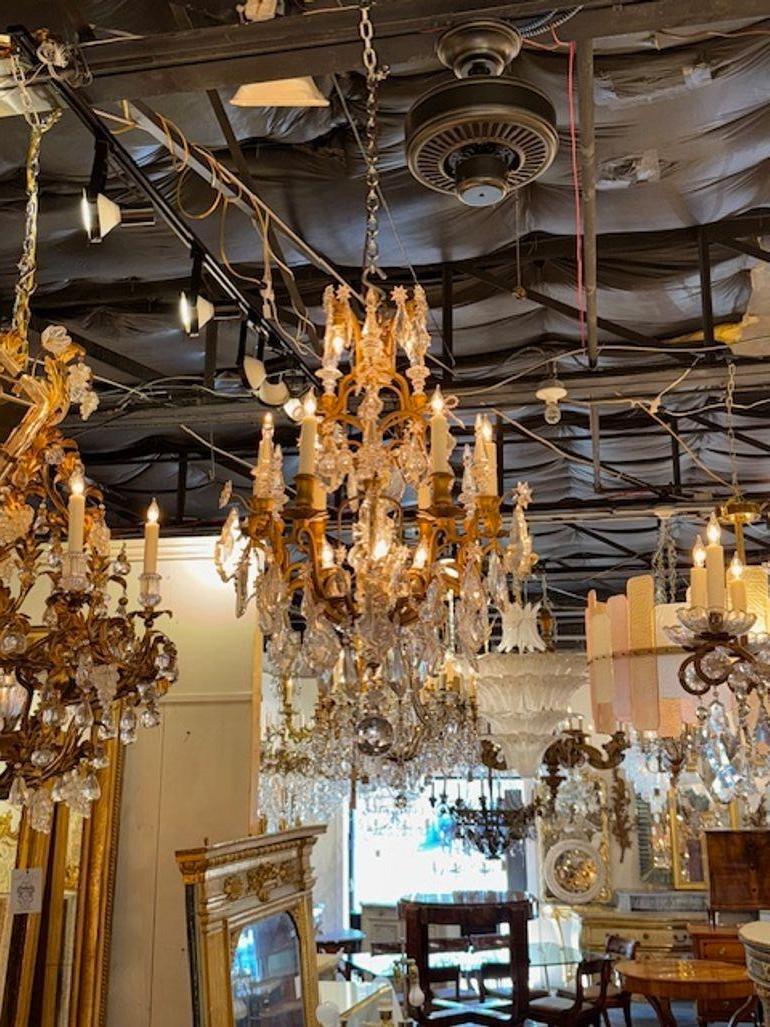 Ce lustre français du XIXe siècle de la manière de Baccarat présente une base en bronze doré exquise et de magnifiques cristaux. Le design reflète l'opulence et l'élégance de l'esthétique française de cette période, avec des détails complexes et un