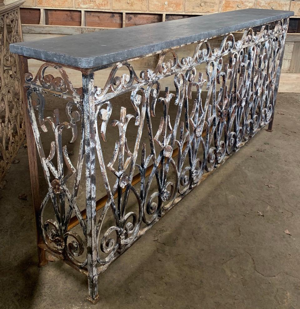 A stunning French iron console table made from elements of a 19th century French balcony. With a later Belgium bluestone top.