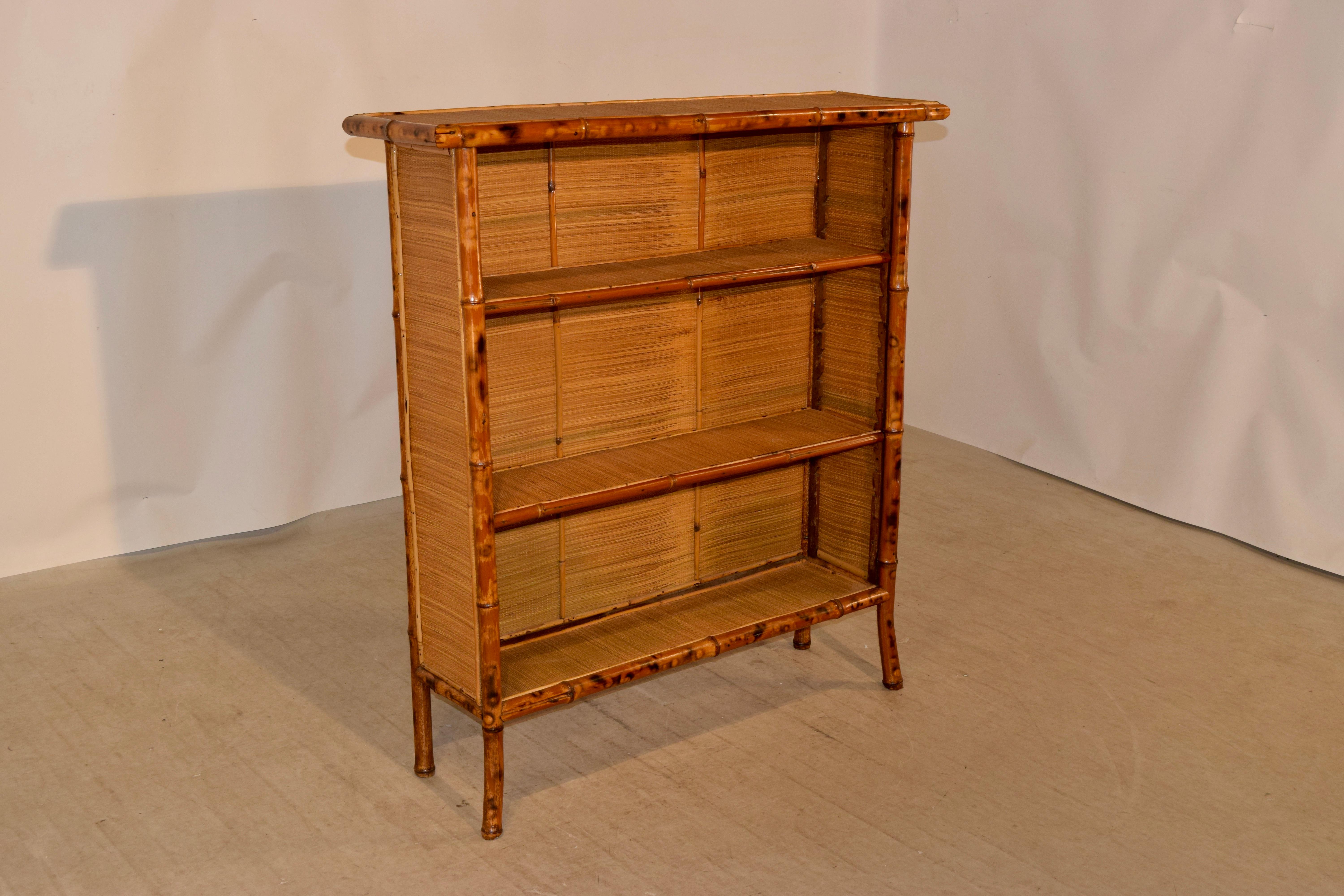 19th century tortoise bamboo bookcase from France with rush covered top, sides, shelves and interior. The bookcase is supported on splayed legs for a lovely added decorative accent.