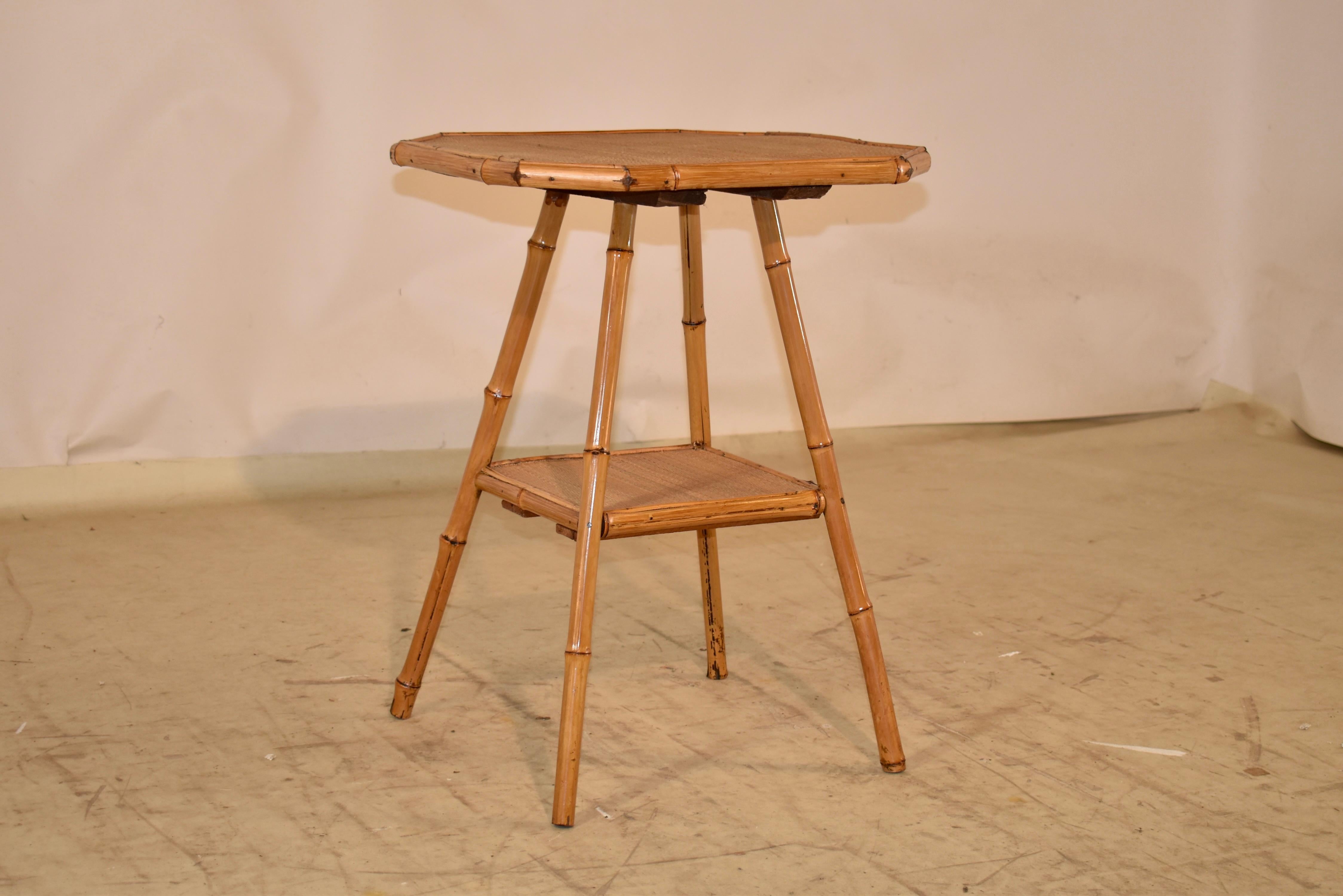 19th century bamboo side table from France.  The top and lower shelf are covered in rush, and the table itself is made from bamboo.  The top of the table is an octagonal shape, and rests upon splayed legs, which are joined by a lower shelf.  
