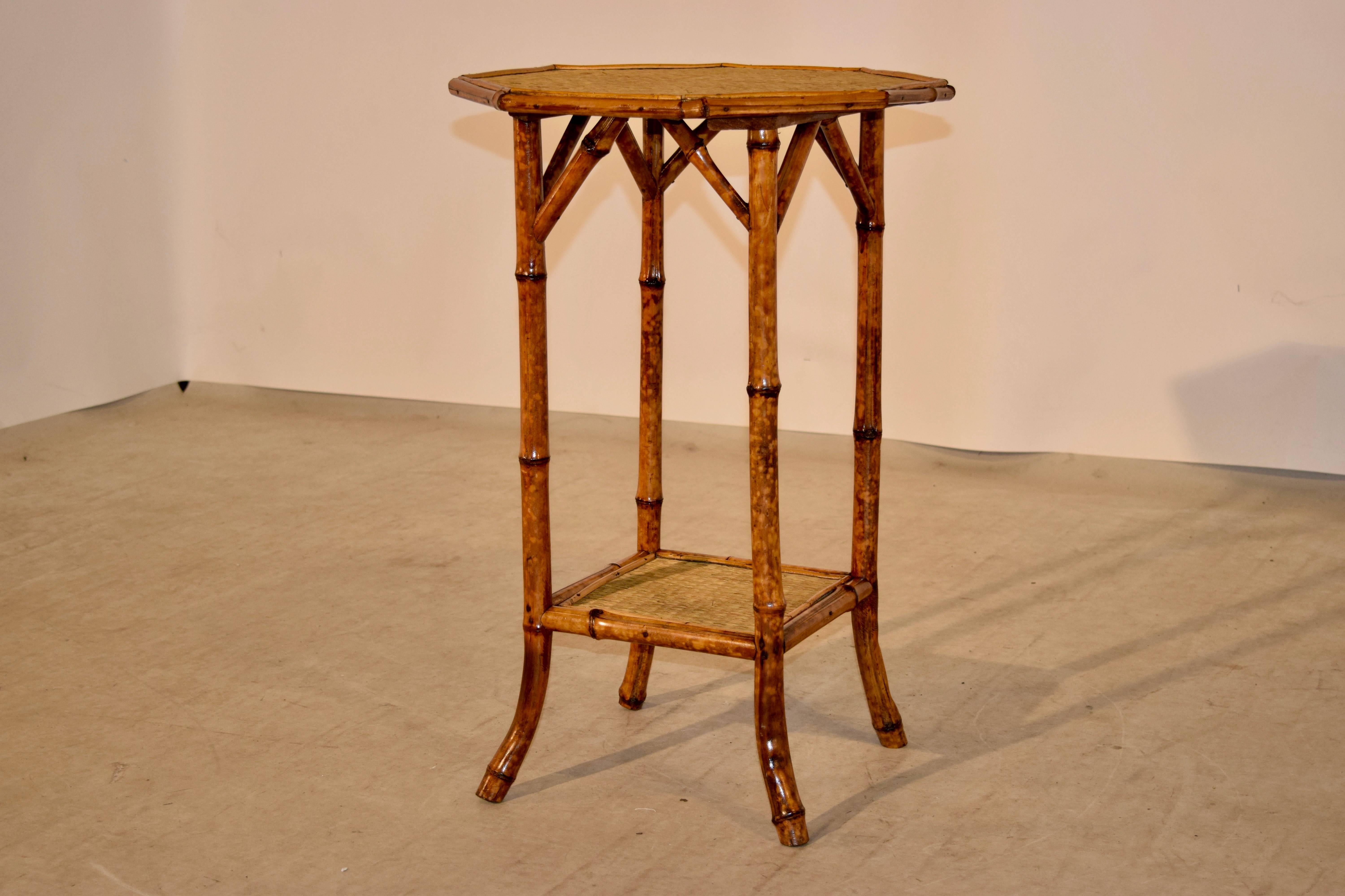 19th century French tortoise bamboo side table with an octagonal shaped top covered in rush with beaded molding around the edge. The splayed legs are joined by a lower shelf which is also covered in rush.