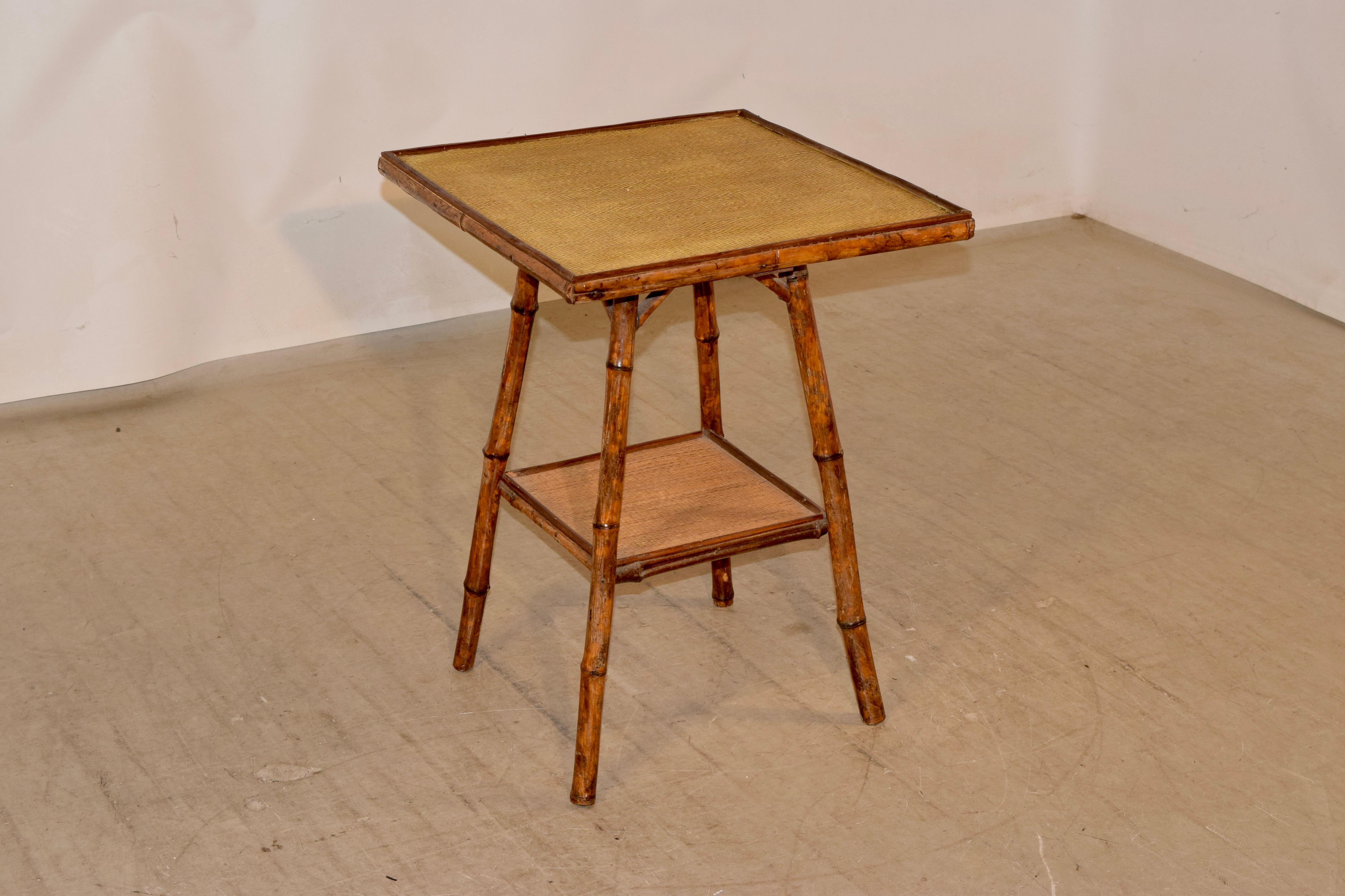 19th century tortoise bamboo side table from France. The table is supported on splayed legs, joined by a lower shelf, which is covered in rush, along with the top.