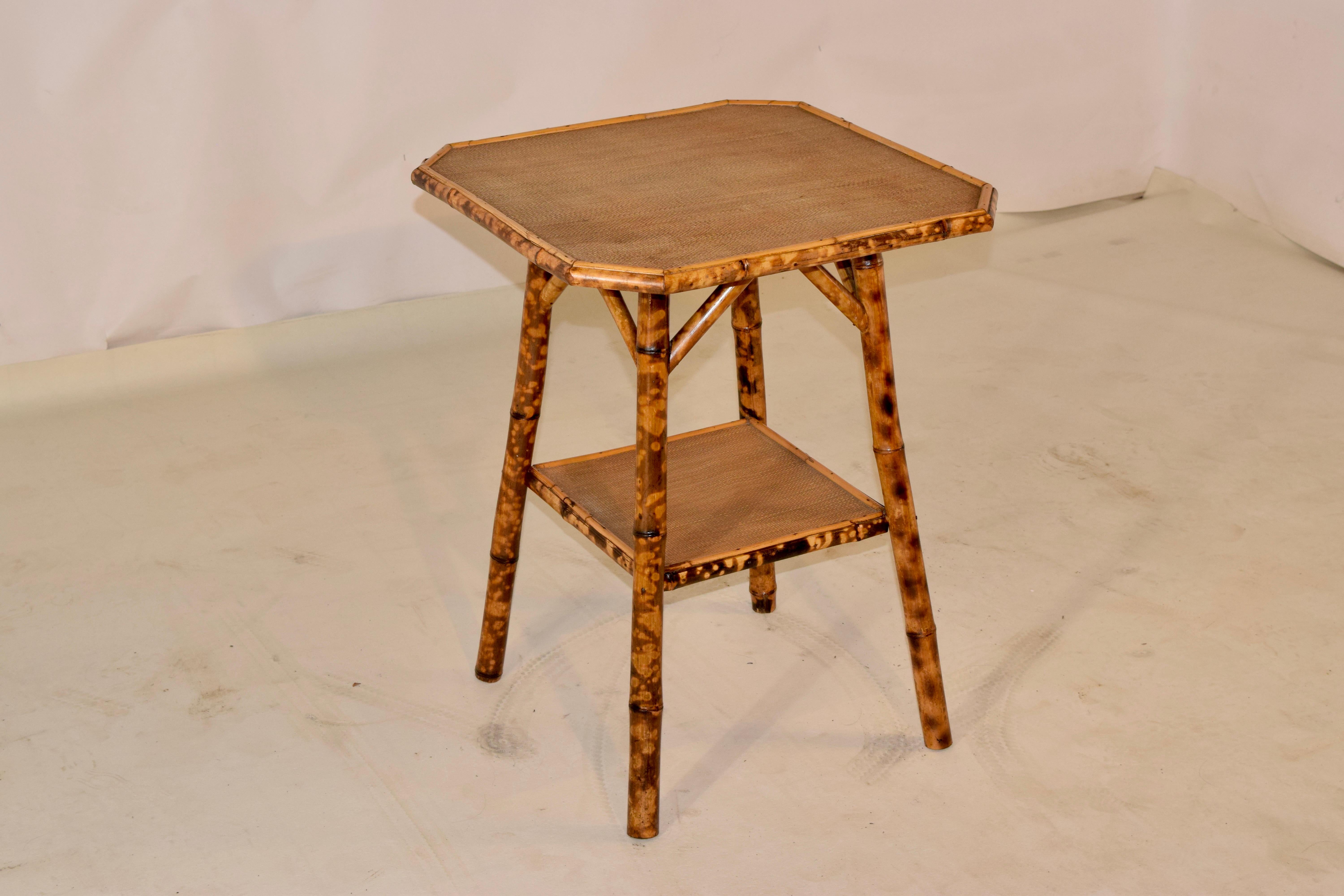 19th century tortoise bamboo table from France with an octagonal shaped top. The top and lower shelf are covered in what appears to be the original rush. Lovely shape and color!.