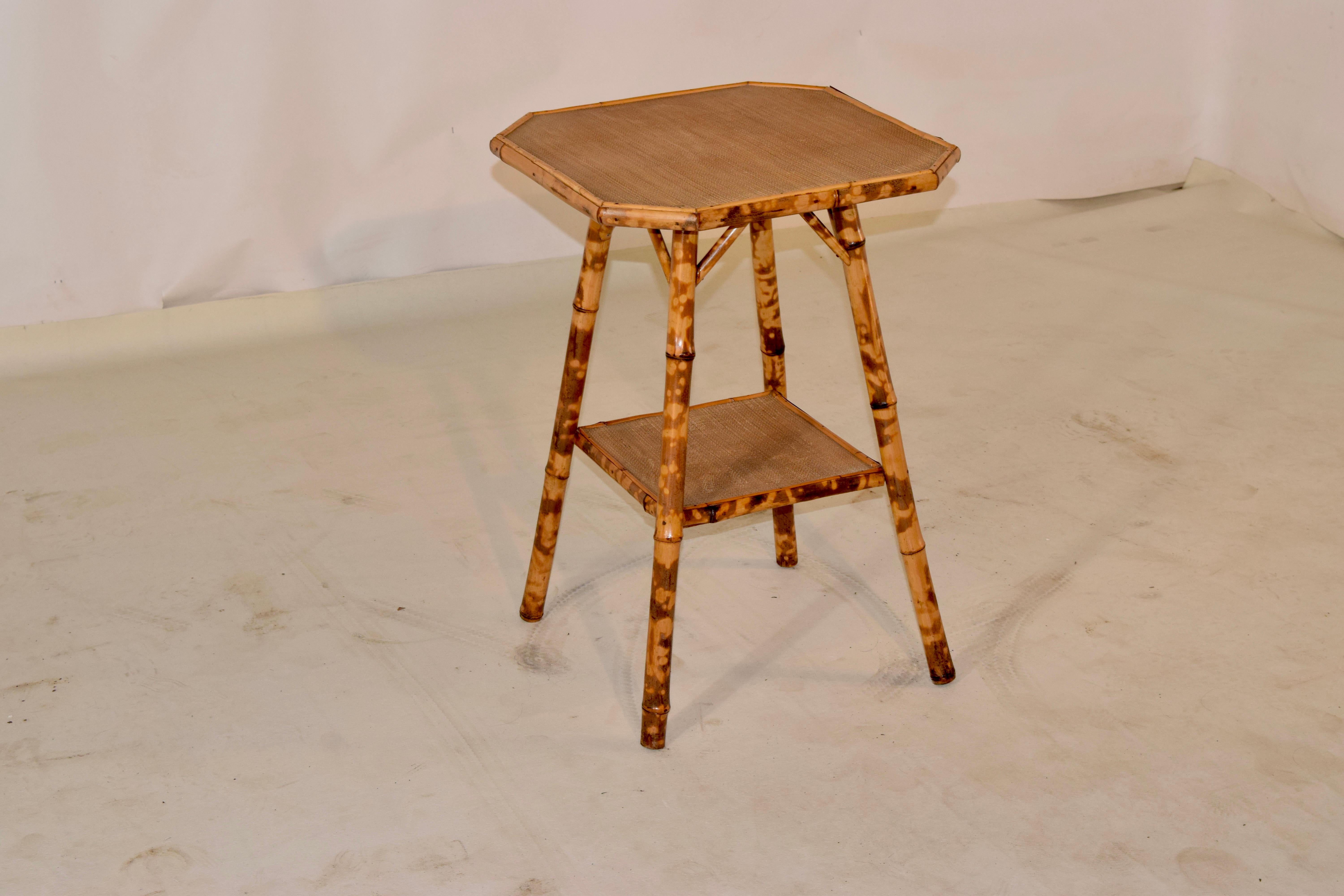 19th century tortoise bamboo side table from France with an octagonal shaped top which is covered in rush. The top is supported on splayed legs, joined by a lower shelf, also covered in rush.
