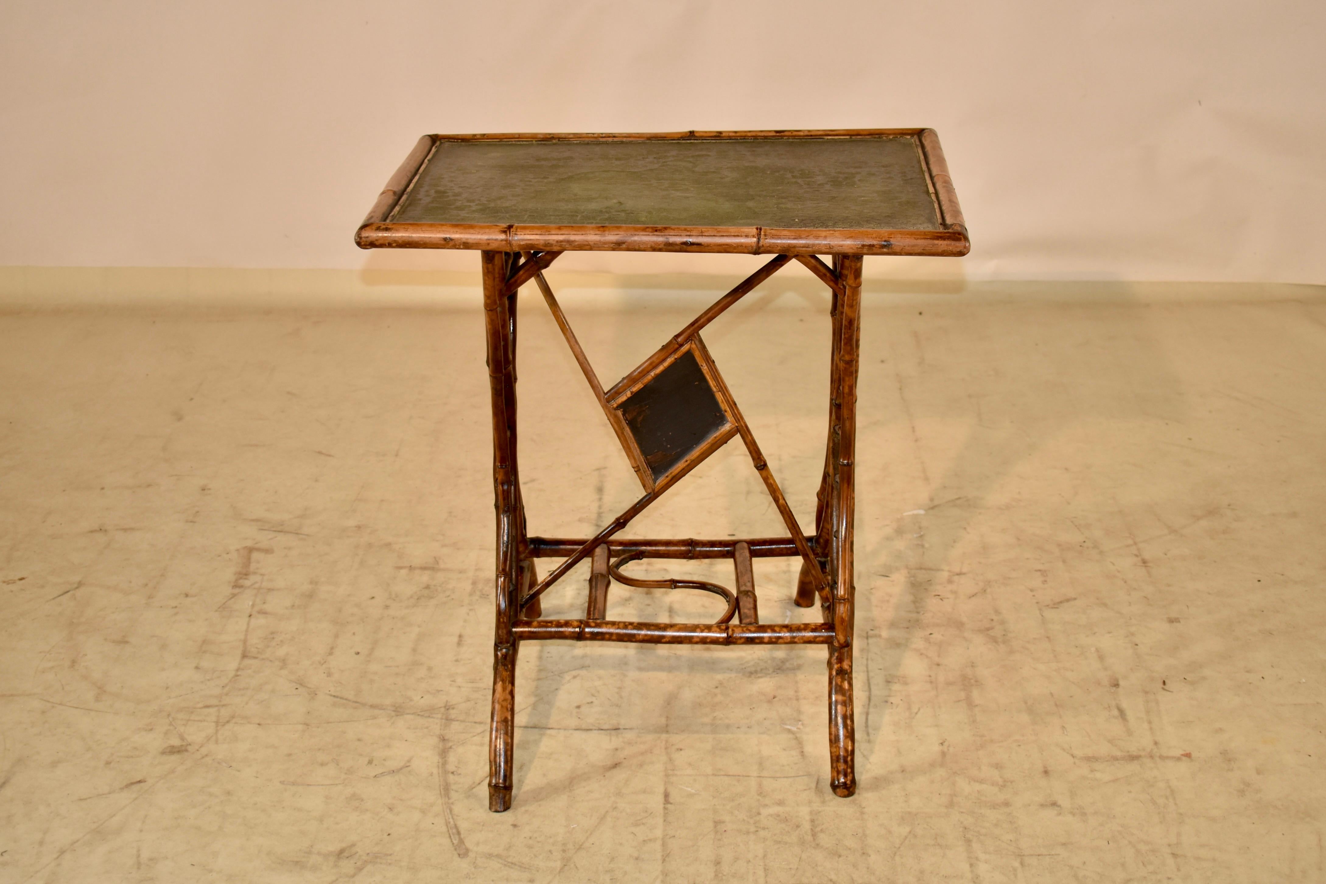 19th century bamboo side table with fantastic original details. The top is in the original green color, which has alligatored to a beautiful patina which was worth saving. The base is made from shaped bamboo to form interesting legs in serpentined
