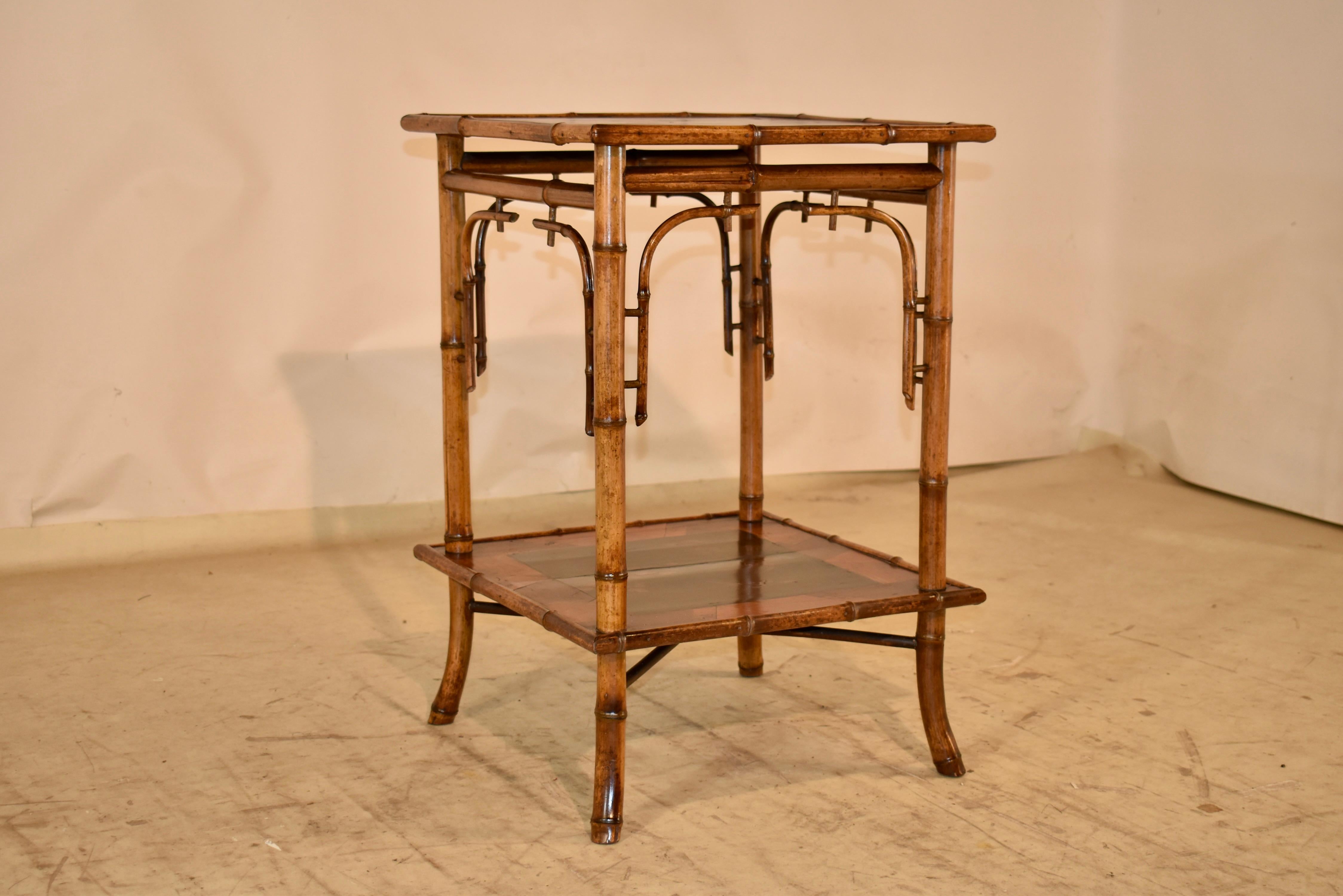Table d'appoint en bambou du 19e siècle provenant de France.  Le dessus est orné d'une bordure en parchemin avec des motifs géométriques, entourant un panneau central peint à la main avec des décorations d'oiseaux et de fleurs.  Le plateau est