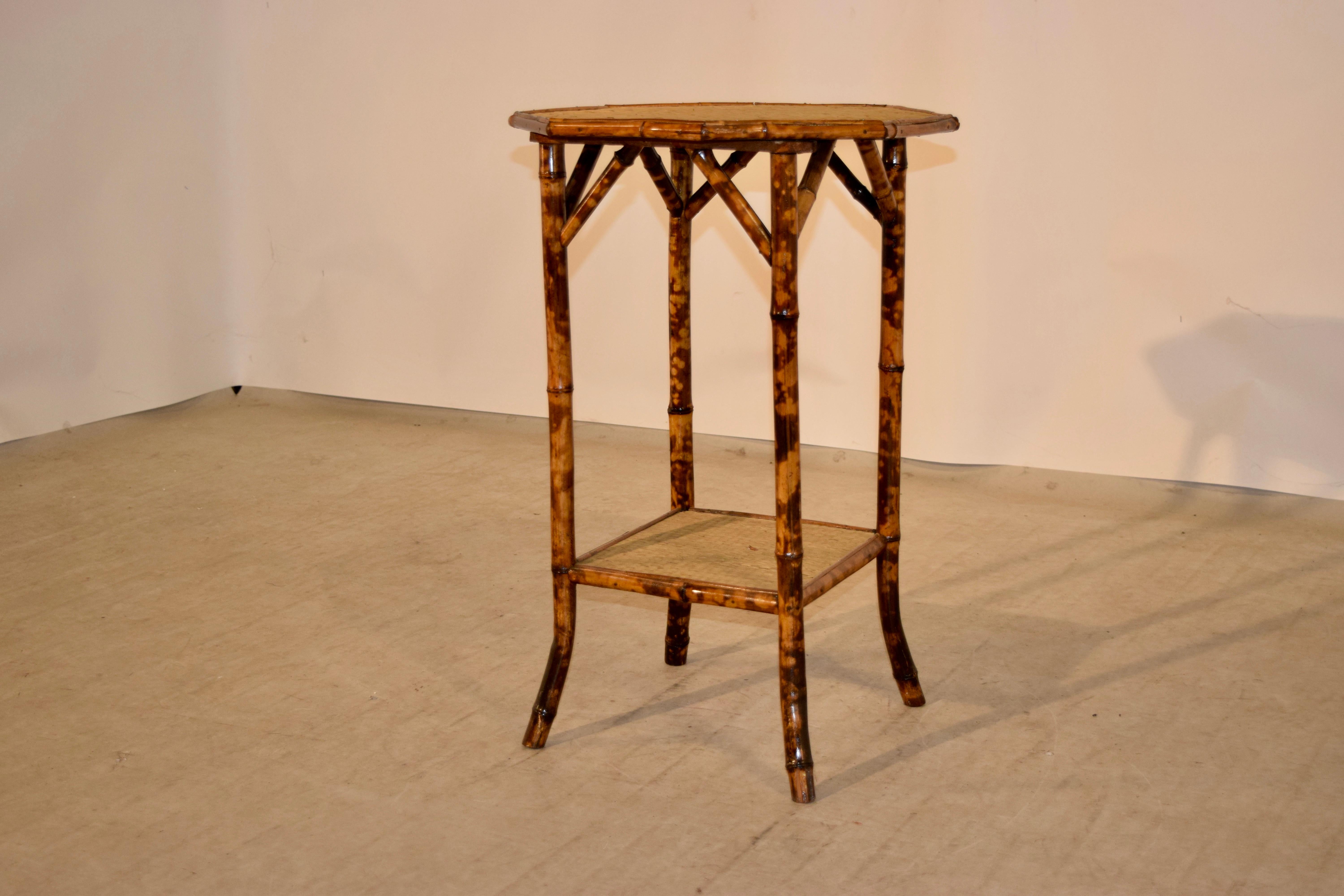 19th century bamboo side table from France with an octagonal shaped top covered in rush, following down to four tortoise bamboo legs, joined at the bottom by a lower shelf, also covered in rush, and splayed feet.