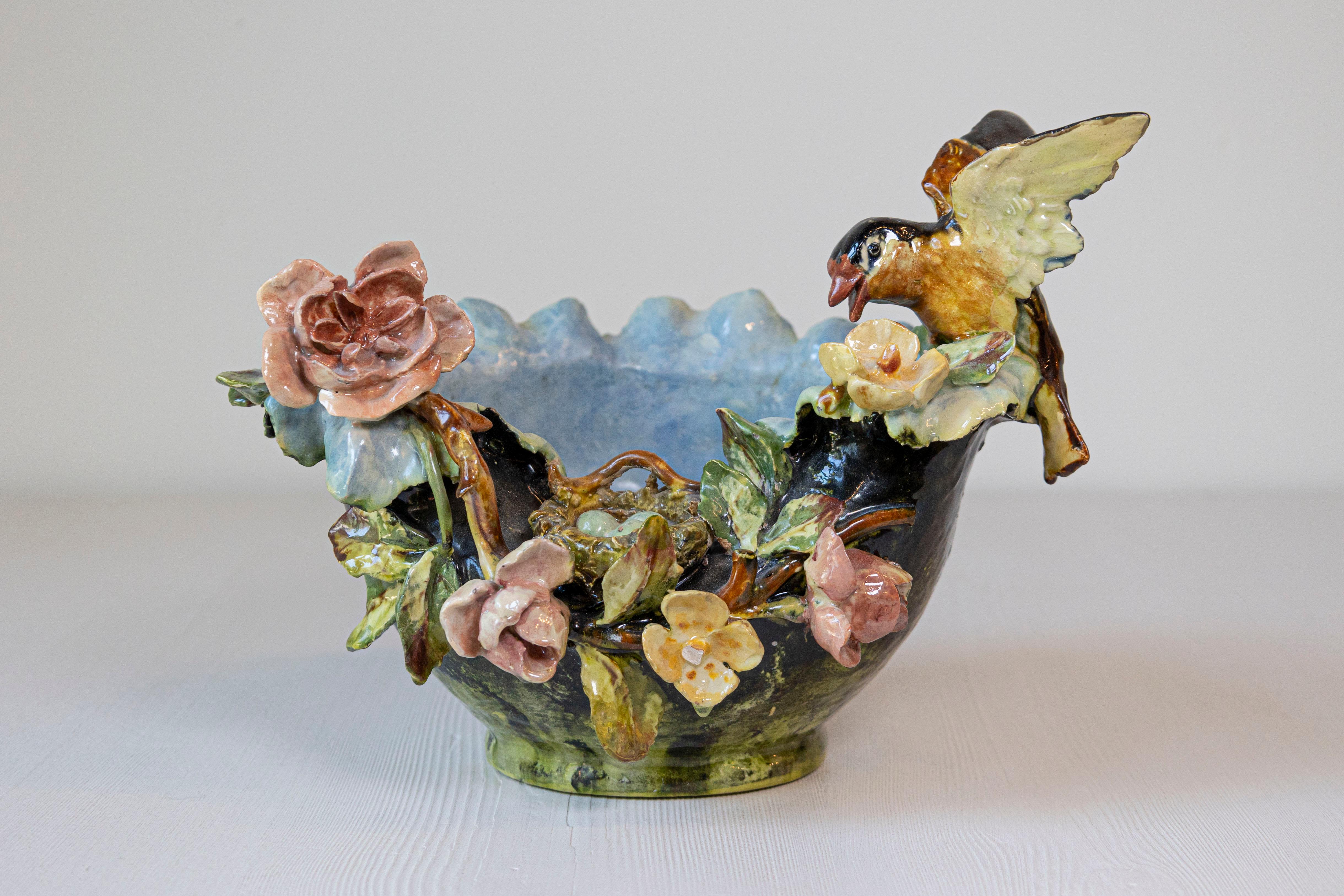 Petite coupe en faïence française du XIXe siècle ornée d'un décor d'oiseau et de nid d'oiseau en Barbotine. Cette poterie française présente un corps de couleur verte, décoré de fleurs colorées exquises. Un petit oiseau vient de se poser sur le