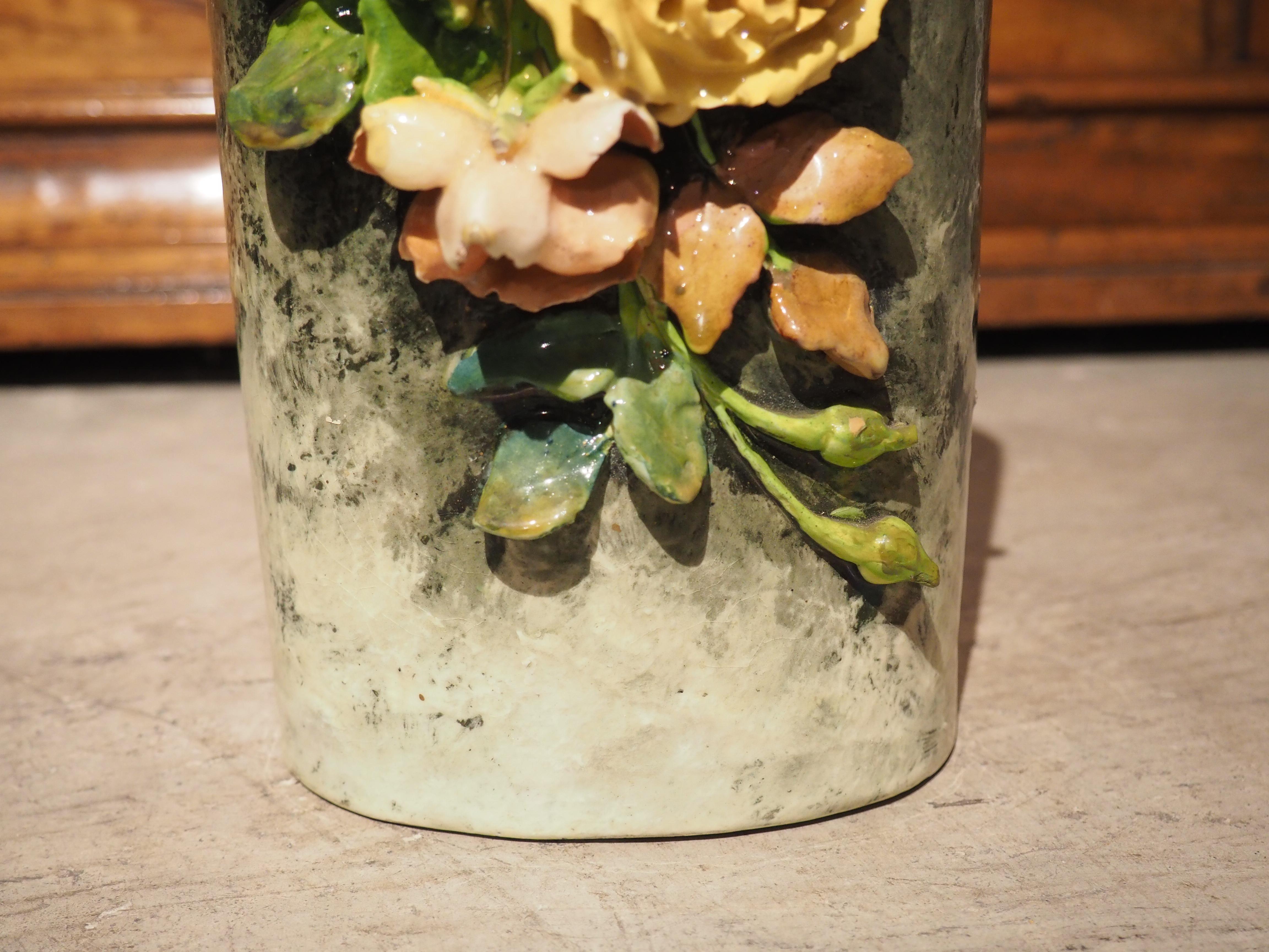Peint à la main en France dans les années 1800, ce magnifique vase cylindrique en Barbotine présente une belle exposition de fleurs fines comme du papier, fabriquées à partir d'argile kaolinique. Ces fleurs en gros relief sont très délicates et leur