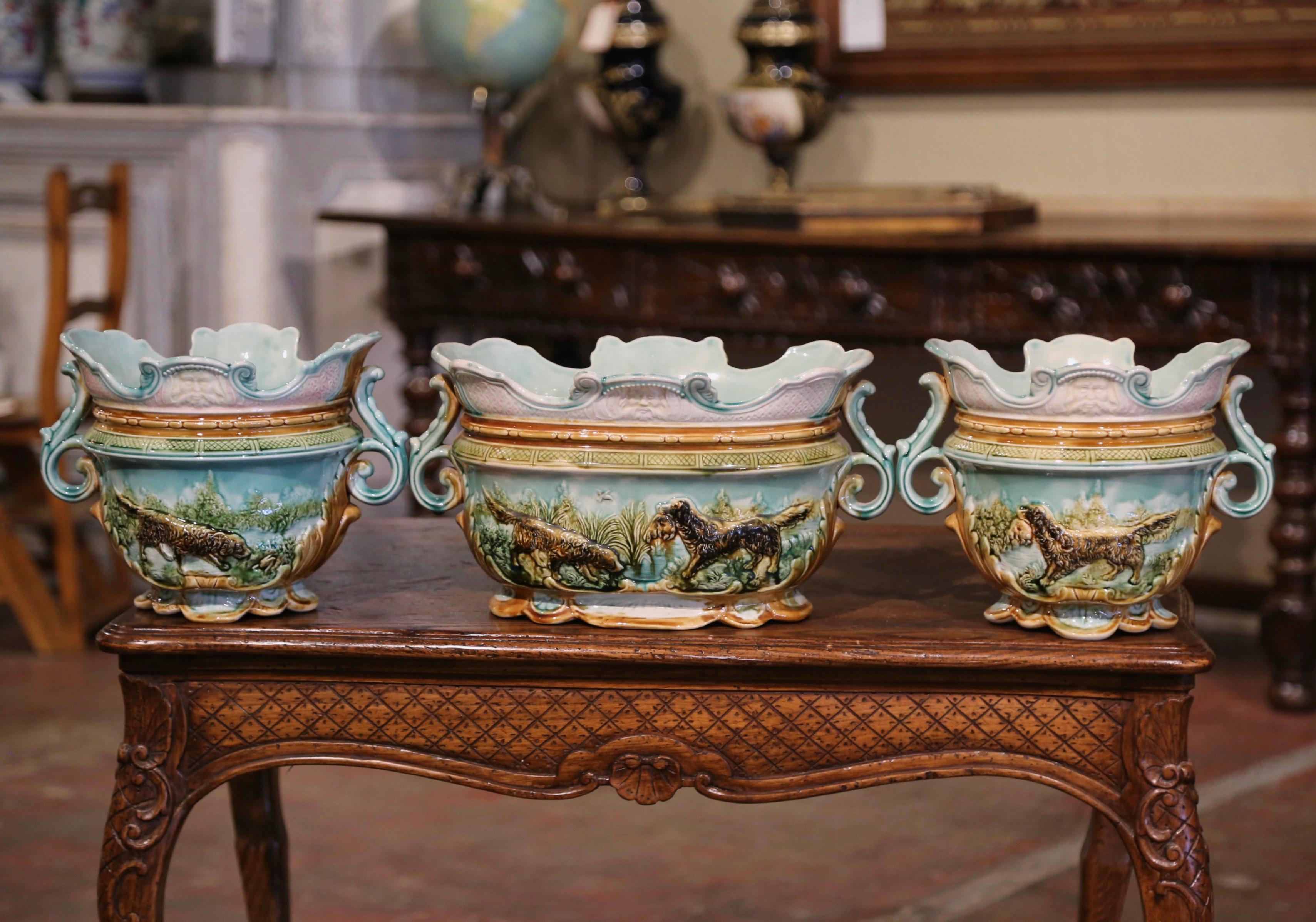 Decorate a buffet or console with this elegant set of majolica cache pots with matching jardiniere. Crafted in France circa 1880, each antique planter is dressed with acanthus leaf form handles, and features a scalloped base as well as a scalloped