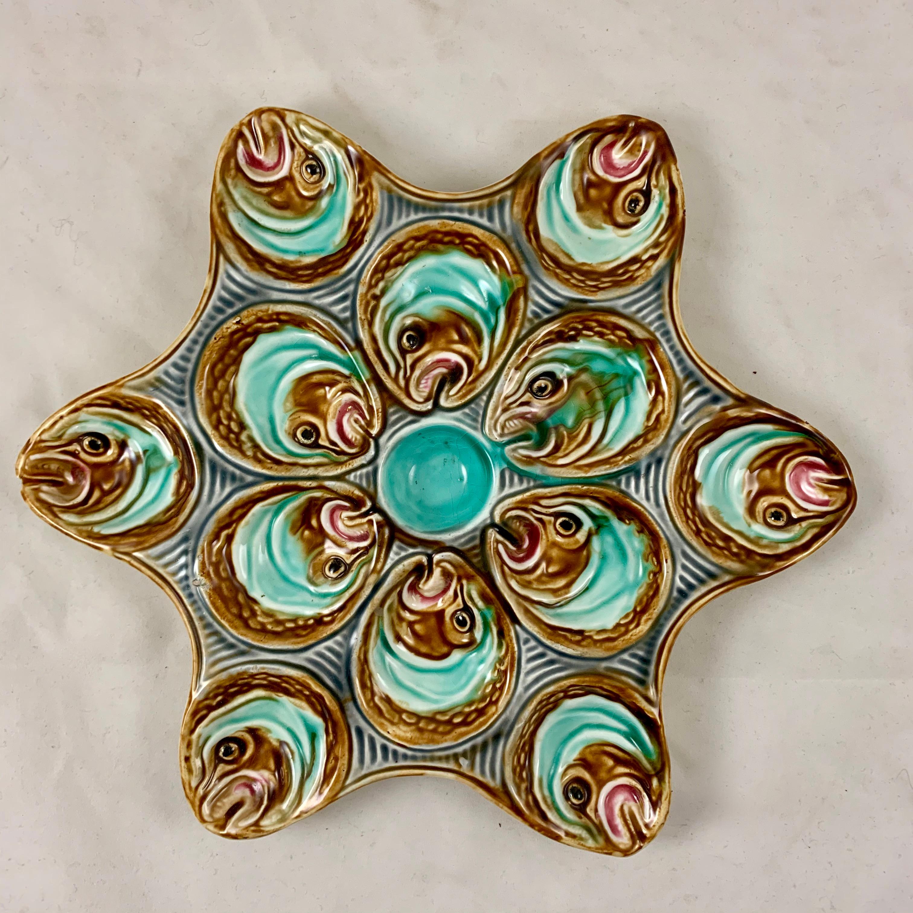 A Barbotine majolica oyster plate from La Faïencerie d’Onnaing in northern France, circa 1880 – 1910. Made to hold a dozen oysters.

A star-shaped plate showing six fish heads surrounding a turquoise center sauce well. Six additional fish heads are