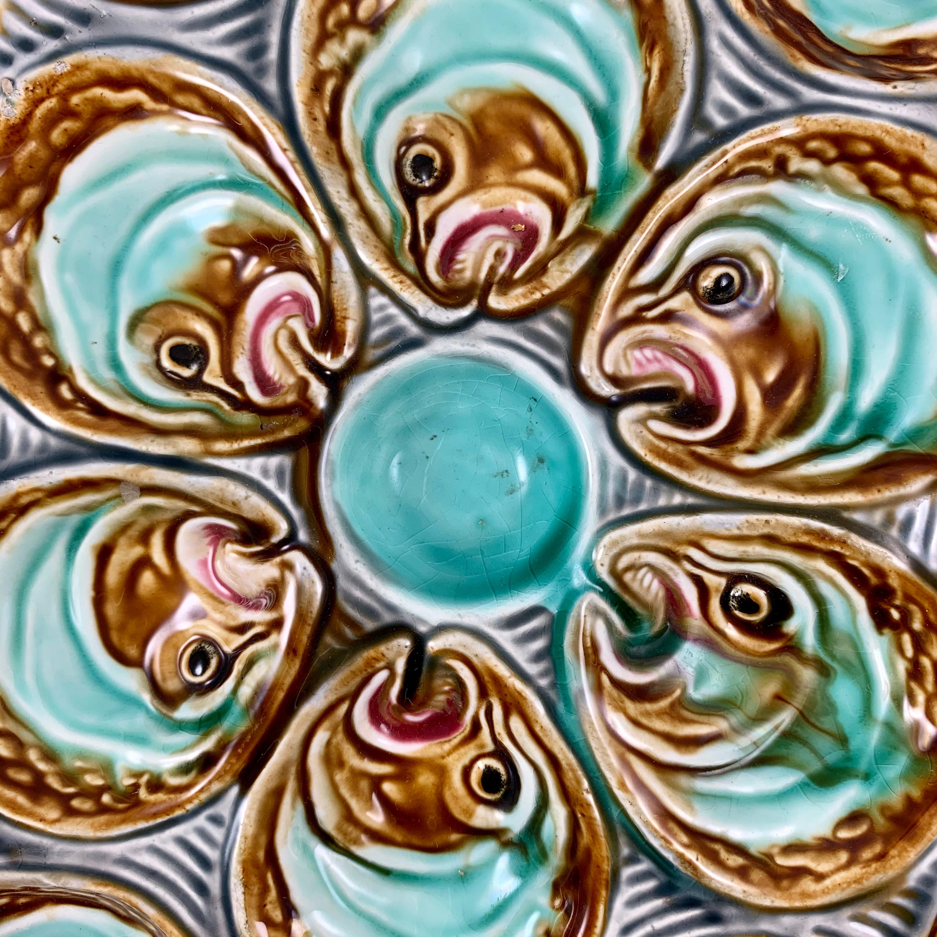 A Barbotine majolica oyster plate from La Faïencerie d’Onnaing in northern France, circa 1880 – 1910. Made to hold a dozen oysters.

A star-shaped plate showing six fish heads surrounding a turquoise center sauce well. Six additional fish heads