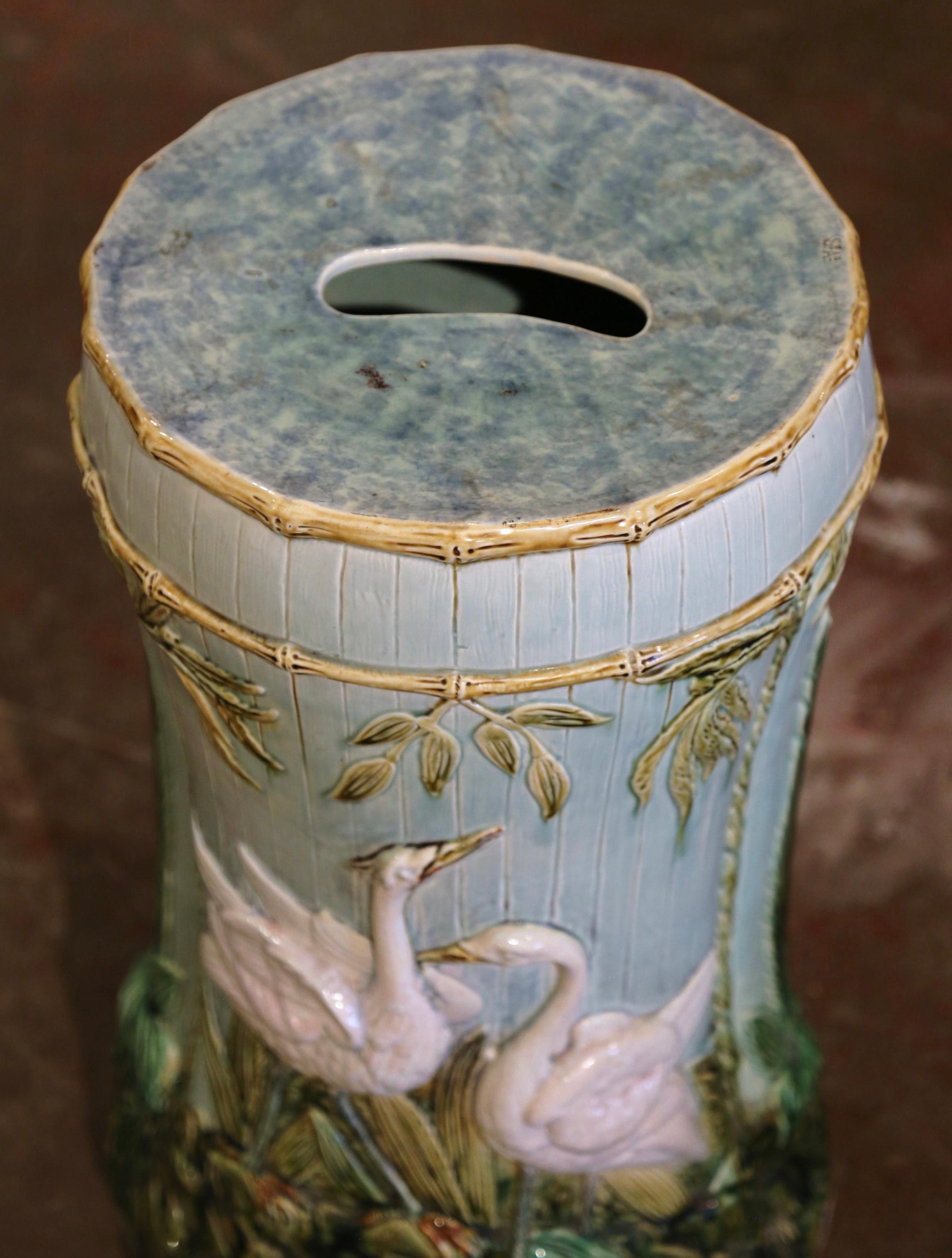 Decorate a patio or a den with this colorful antique majolica garden stool with bird motifs. Created in France circa 1890, the seating with central handle features wonderful swan decor in high relief on both sides, decorated with reef and foliage