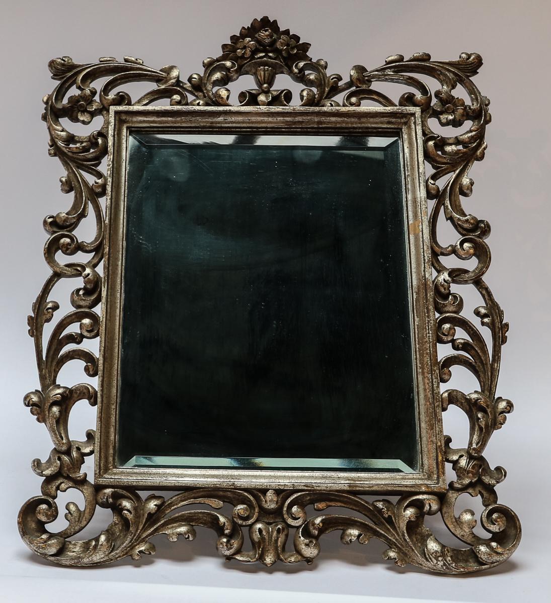 Miroir de courtoisie ou miroir mural de style baroque du 19e siècle, orné de bois doré argenté et de verre biseauté. Peut également être accroché au mur avec le fil de fer attaché.