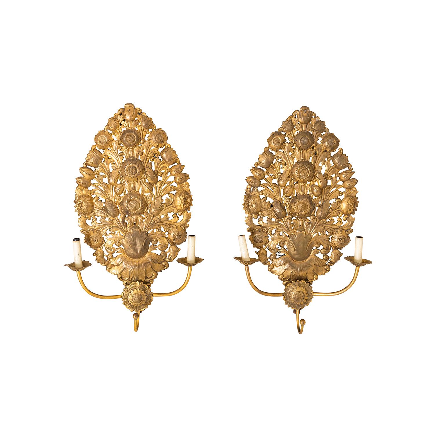 An antique French Baroque pair of wall appliques, sconces made of hand crafted gilded brass in good condition. The sculptured lights, lamp are featuring a two light socket. The Parisian décor pieces are particularized with sunflowers and roses. The