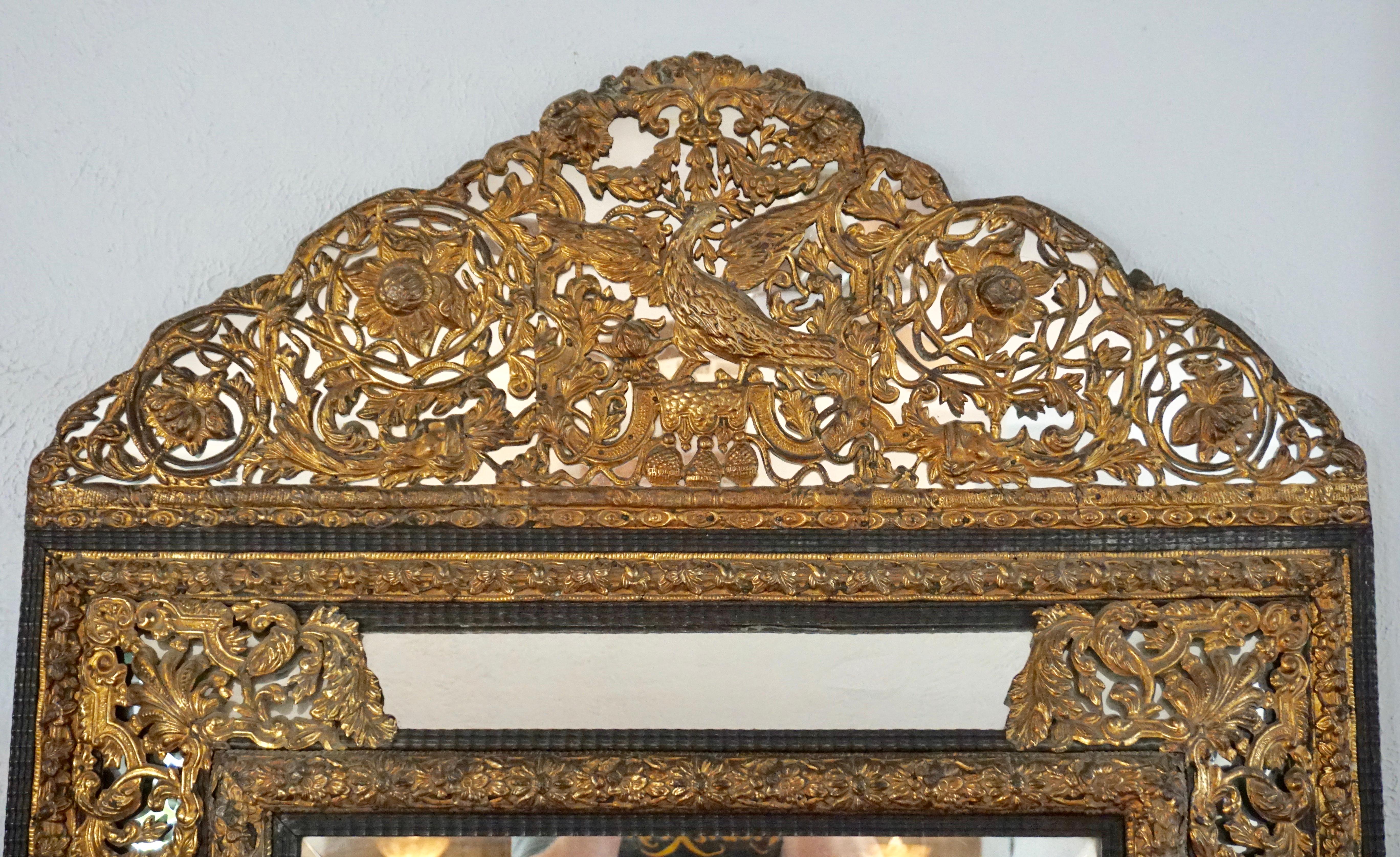 A stunning gilt metal repousse and ebony carved wood Baroque style Cusion mirror from the estate of Lois and Buzz Aldrin (Moon landing Astronaut). This is a large and heavy solid wood and glass mirror (replaced modern mirrors) with exquisite