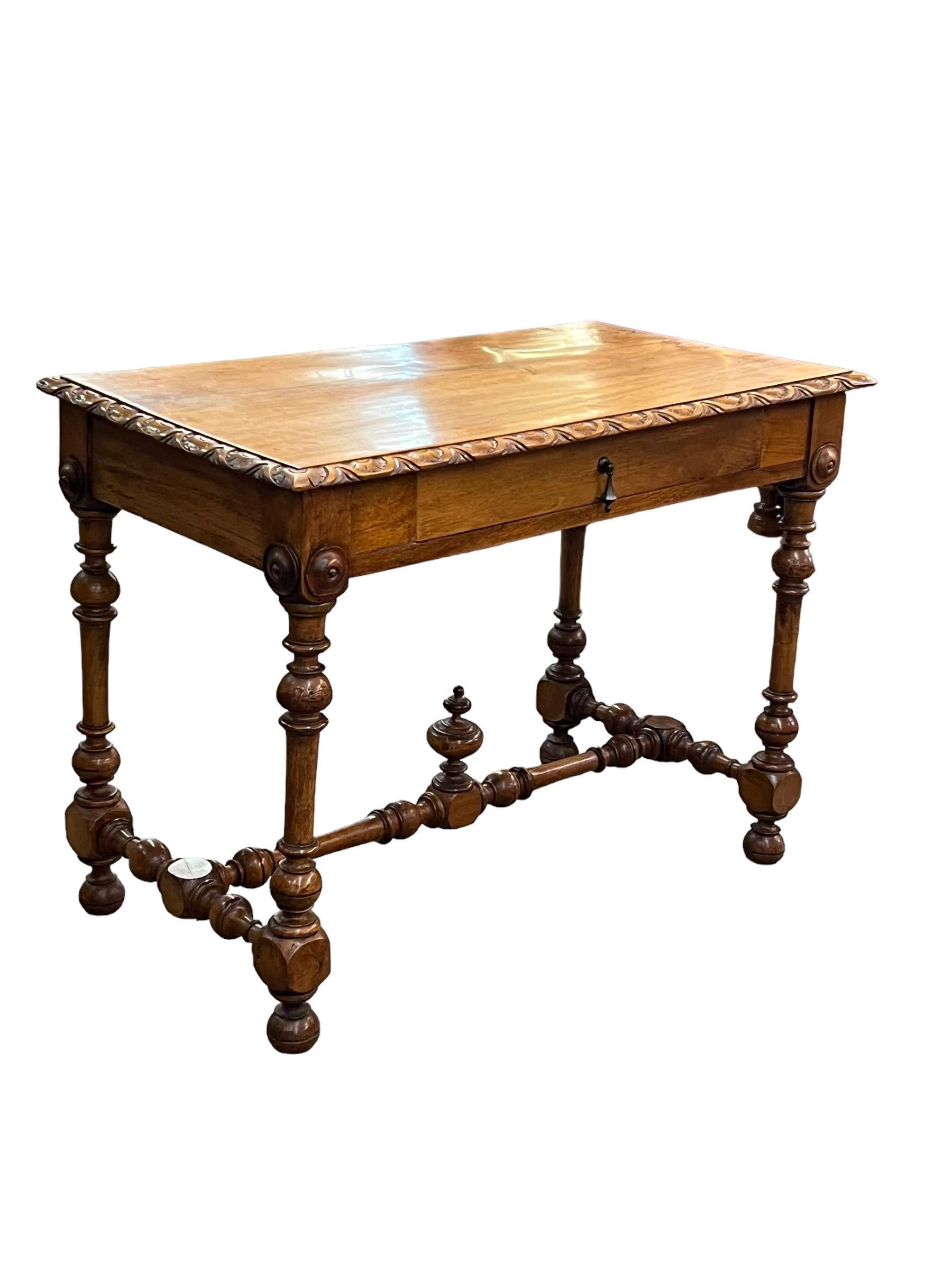 Elegant 19th century French Baroque style fruitwood writing table with tapered turned legs, x-Vintage Gold Mirror With Detailed Base stretcher with urn finial; single drawer. The top panel is made from one solid slab waith hand carved
