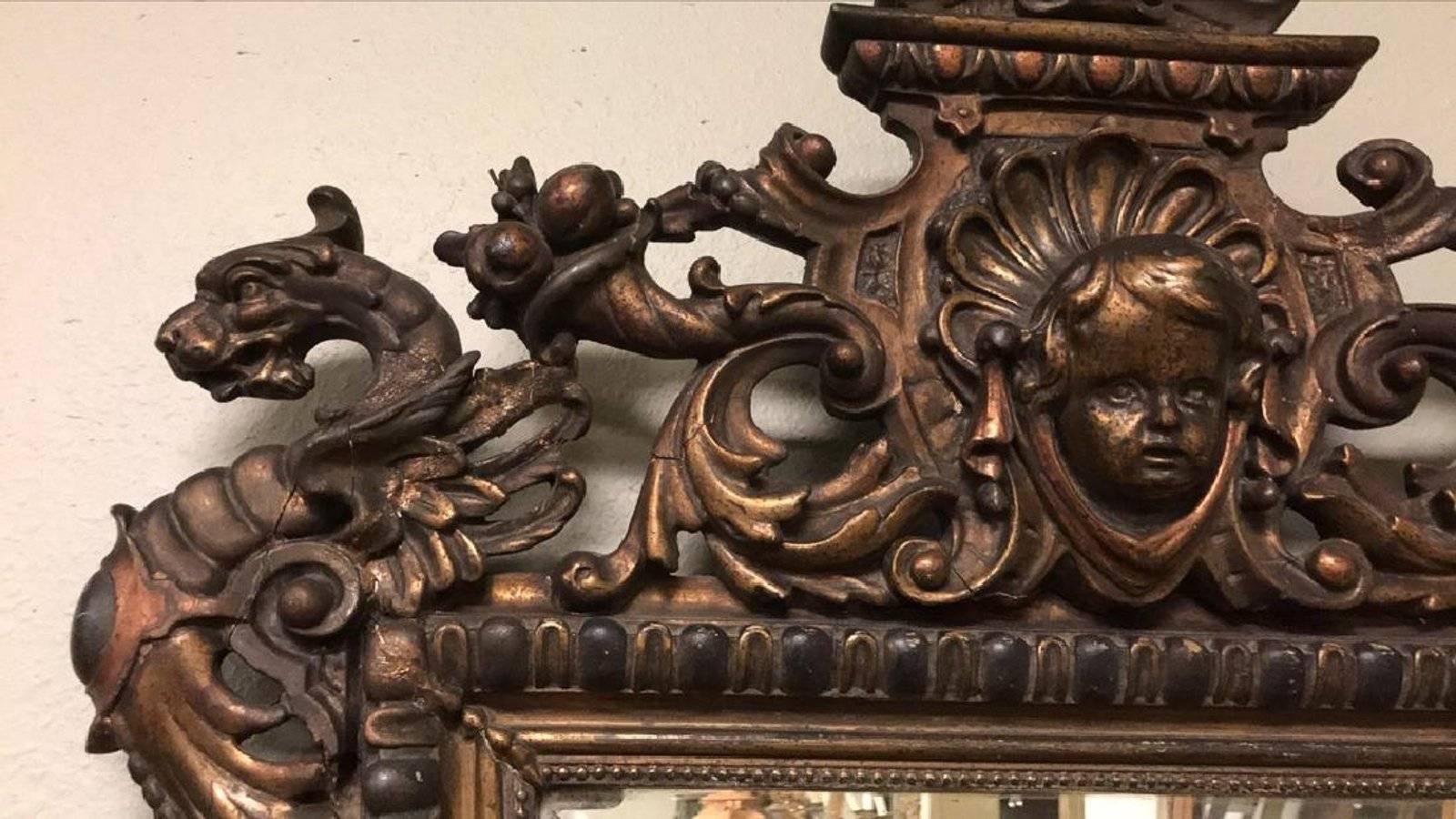 Exceptional 19th century French baroque bevel edged wall mirror of tapering form. Ornately carved with leaf scrolls, cherub masques, dragon heads, shells, and baskets of festoon with old gold leaf finish,

circa 1870

Good condition but damage