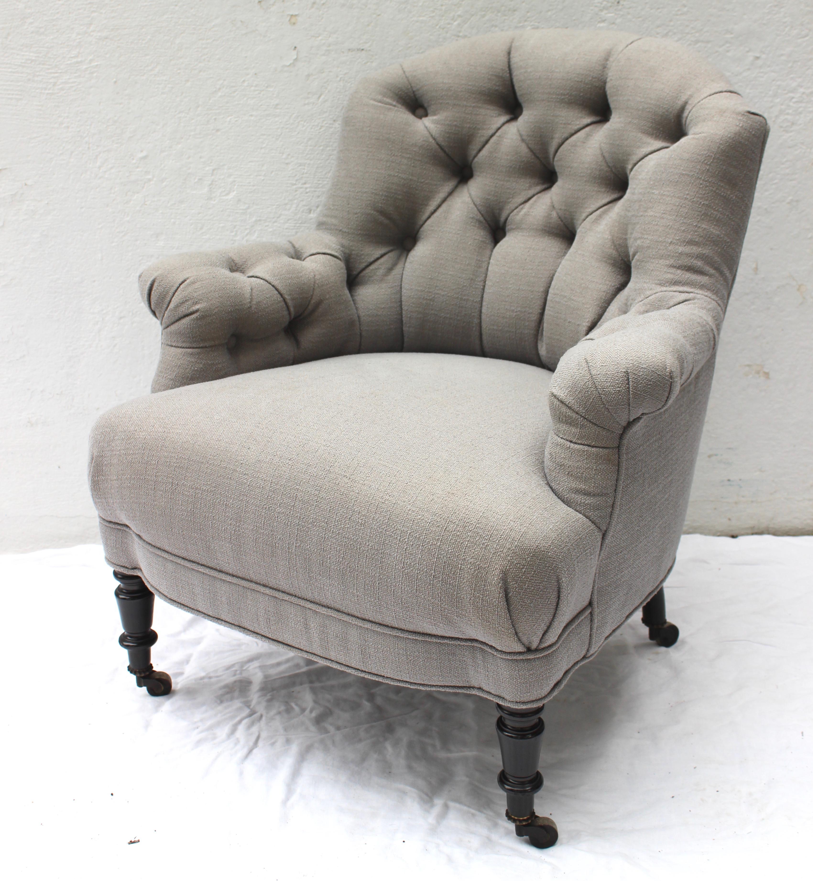 19th century French round back button tufted armchair... New upholstery and ebonized legs on casters.