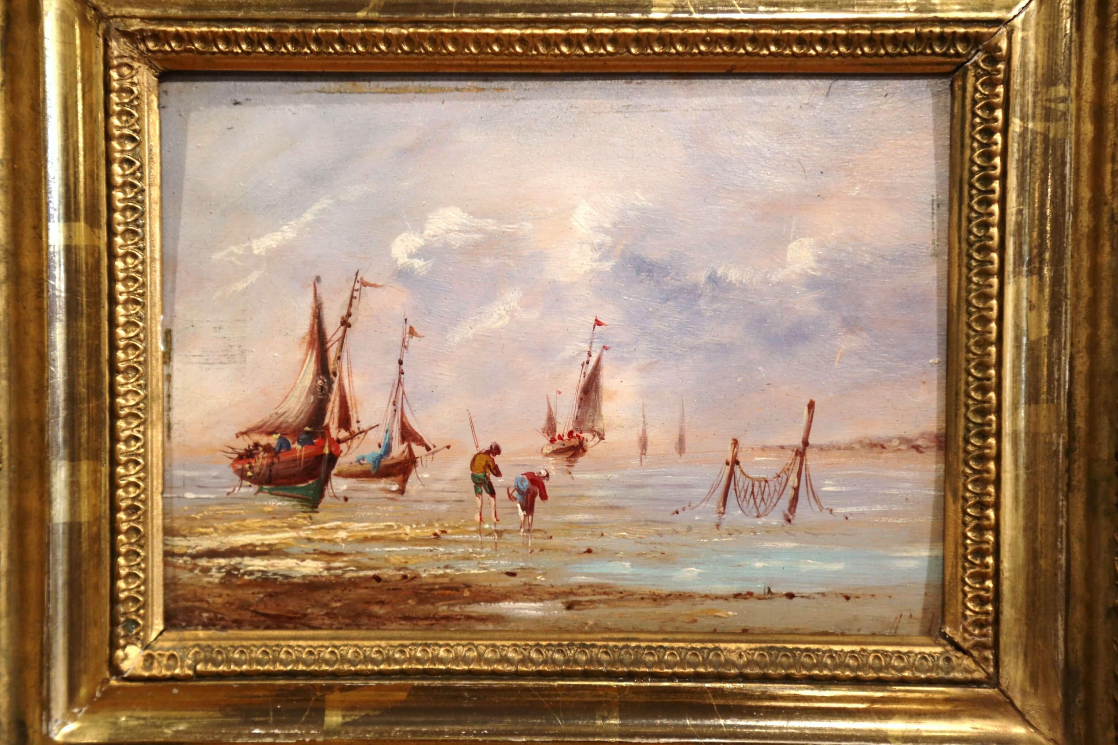 Set in the original carved gilt frame, this small oil painting on board was created in France, circa 1860; it features a typical fishing scene on the Brittany coast, with two people picking shellfish and sailboats in the background. The painting is