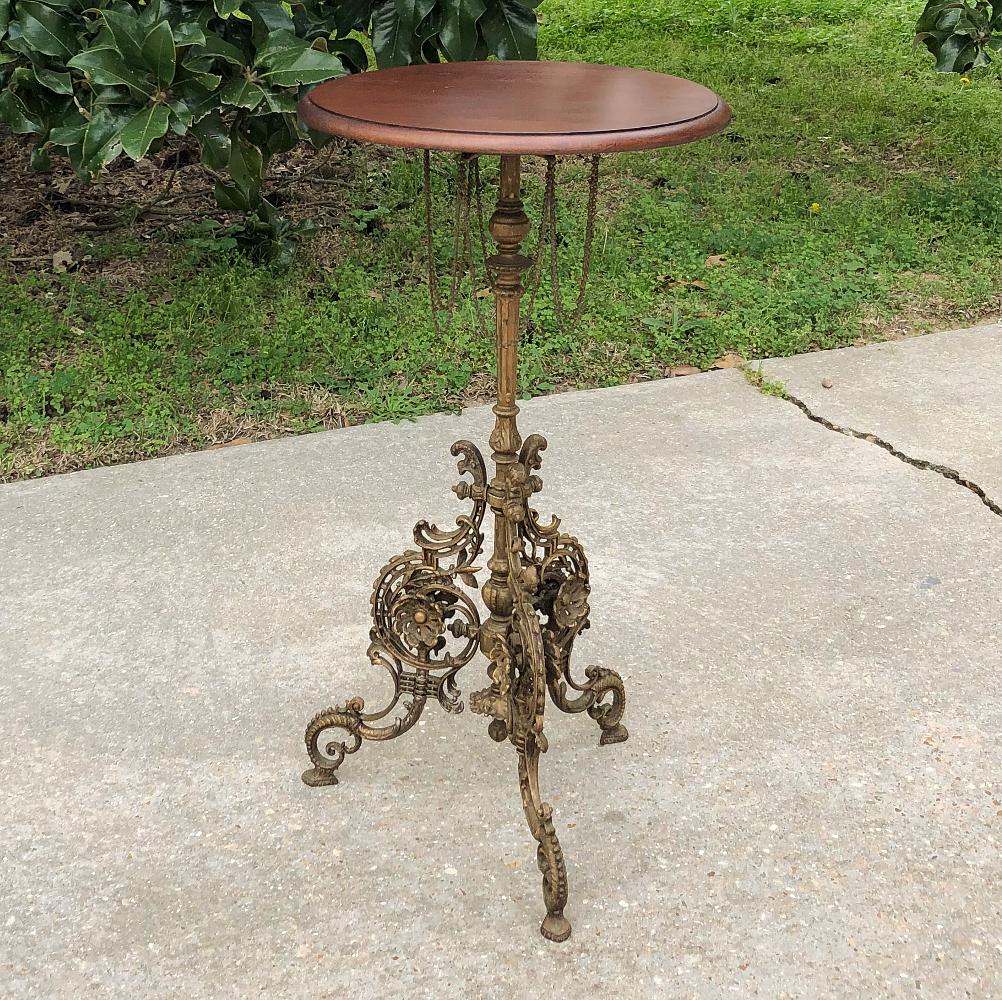 19th century French Belle Époque cafe table with painted cast iron base is a remarkably detailed work of art! Under the unassuming round walnut top is where the magic begins, with decorative chairs looped in a circle around the central shaft, which