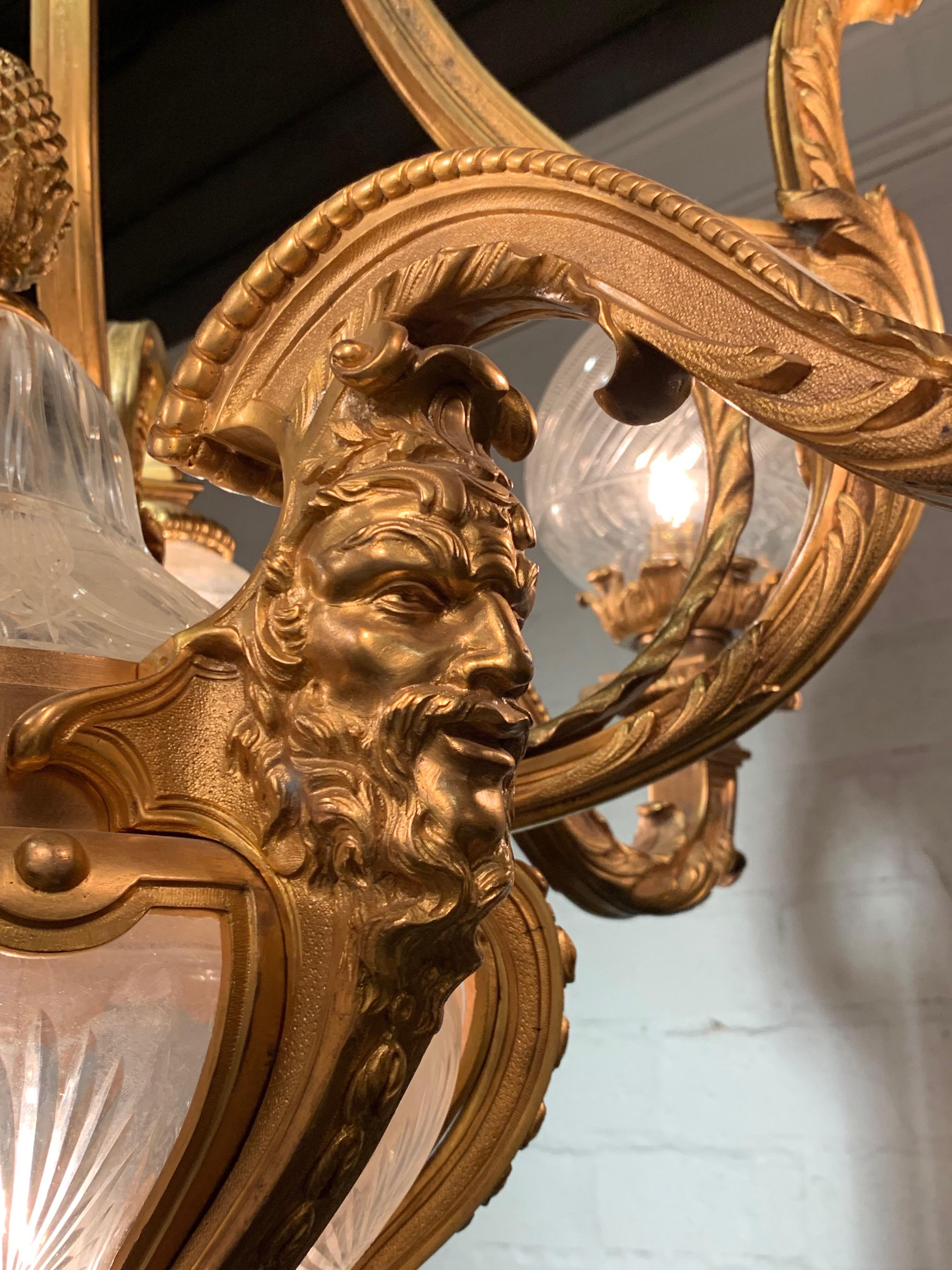 Außergewöhnlicher französischer Belle-Époque-Kronleuchter aus vergoldeter Bronze des 19. Jahrhunderts mit 10 Lichtern. Beachten Sie die erstaunlichen Details, darunter das Gesicht eines Mannes auf dem Sockel der Halterung. Auch schöne geätzte