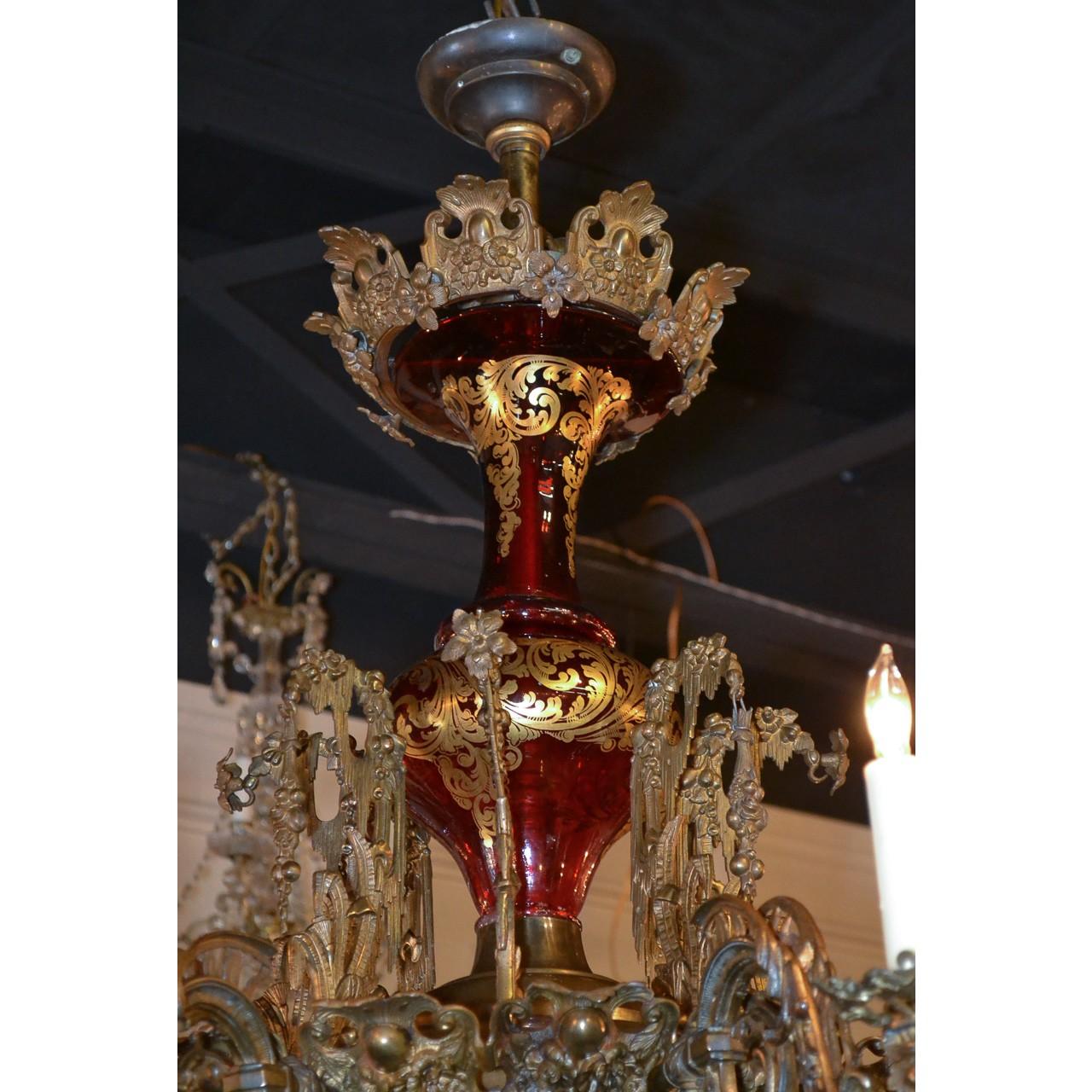Magnificent and rare 19th century French Belle époque eight-light chandelier with an embossed leaf-spray bronze canopy atop a shaped ruby glass stem decorated with gold stylized leaf overlay. The brass mid-section with superb flower-head and leaf