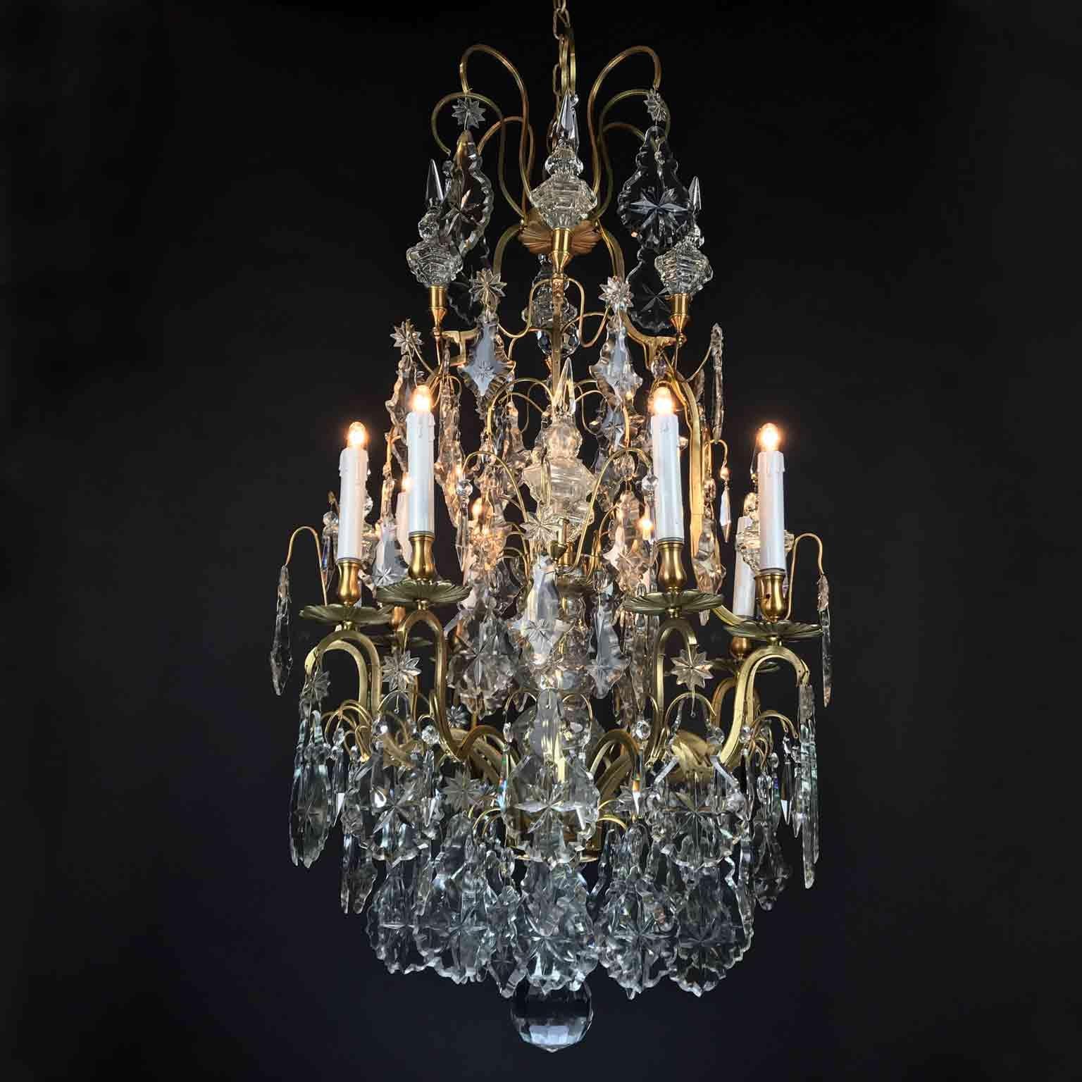 A romantic Louis XV style crystal chandelier of French origin, an eight-light pendant dating back to the late 19th century, realized with a vertical bronze structure, a birdcage shaped frame, topped by crystal elements and adorned with crystal