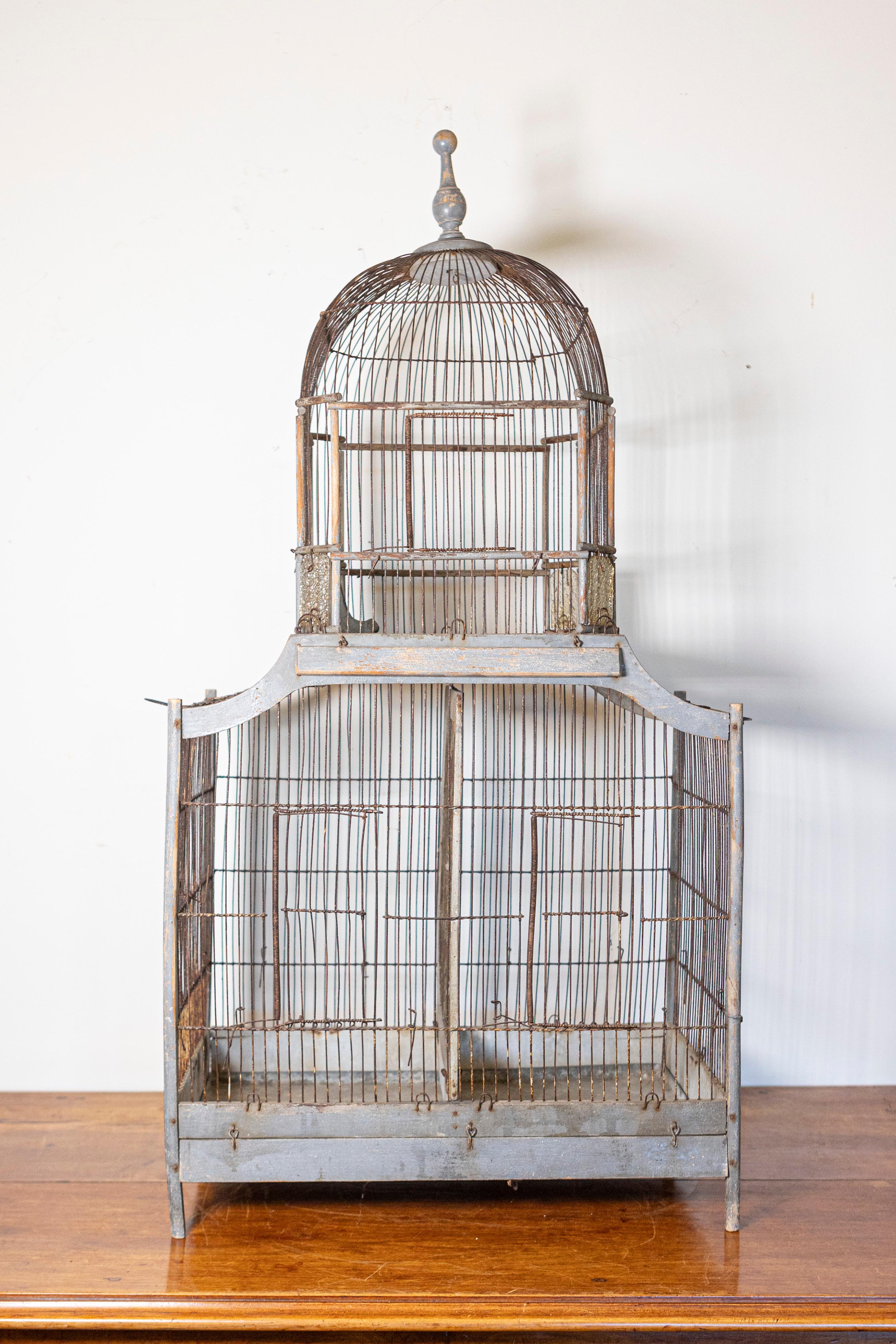 A stunning example of 19th-century French craftsmanship, this large birdcage features a distinctive pagoda-shaped silhouette, blending architectural elegance with practical design. Constructed with a painted wooden frame and fine metal bars, the