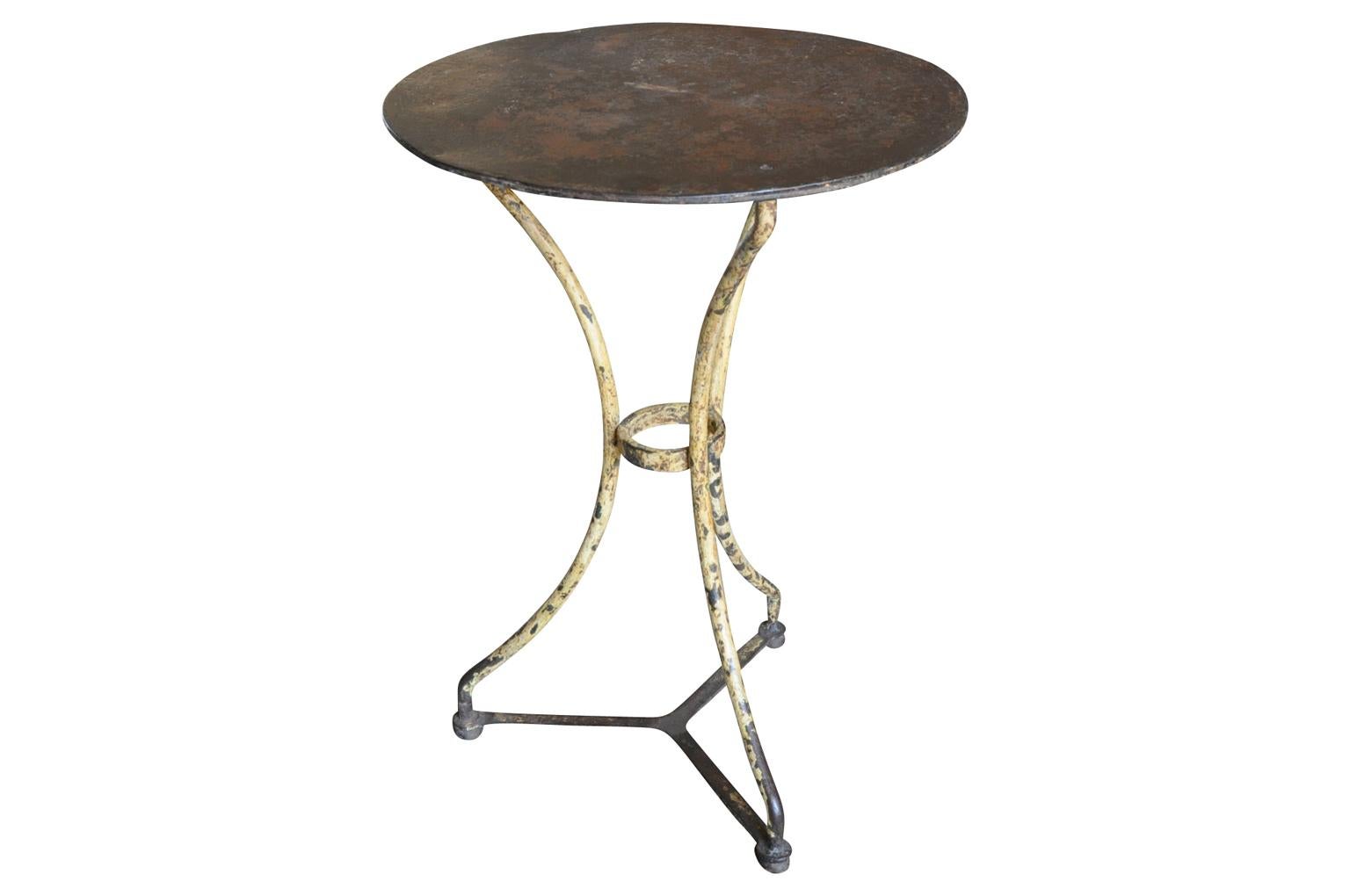 A very charming later 19th century bistro table from the Provence region of France. Soundly constructed from cast iron with its original paint. Terrific patina. A perfect accent piece for any interior or garden.