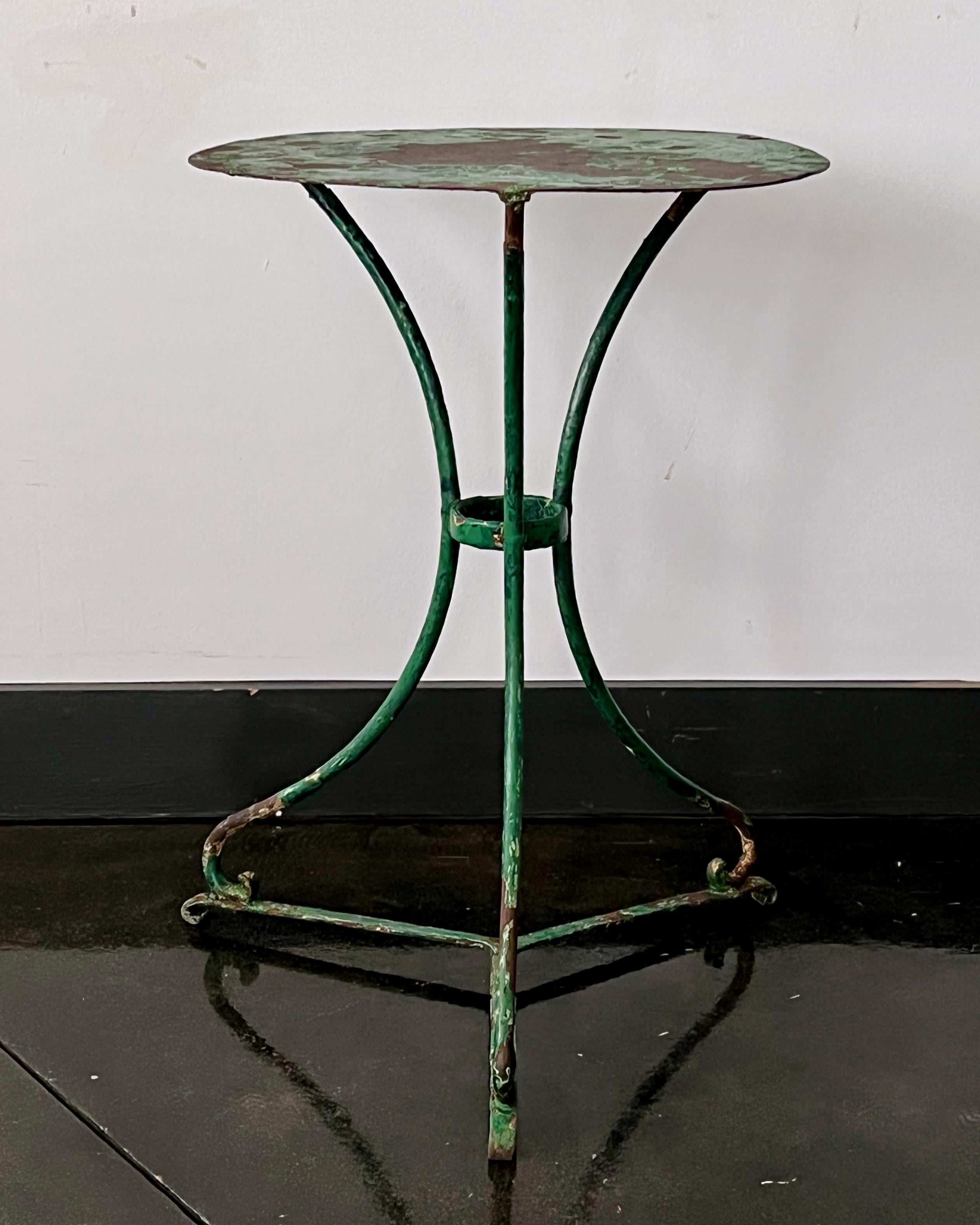 Table de bistrot française de la fin du 19ème siècle avec de nombreuses couches anciennes usées de tons verts. Riveté, avec des pieds galbés en fer forgé et un plateau en acier métallique.