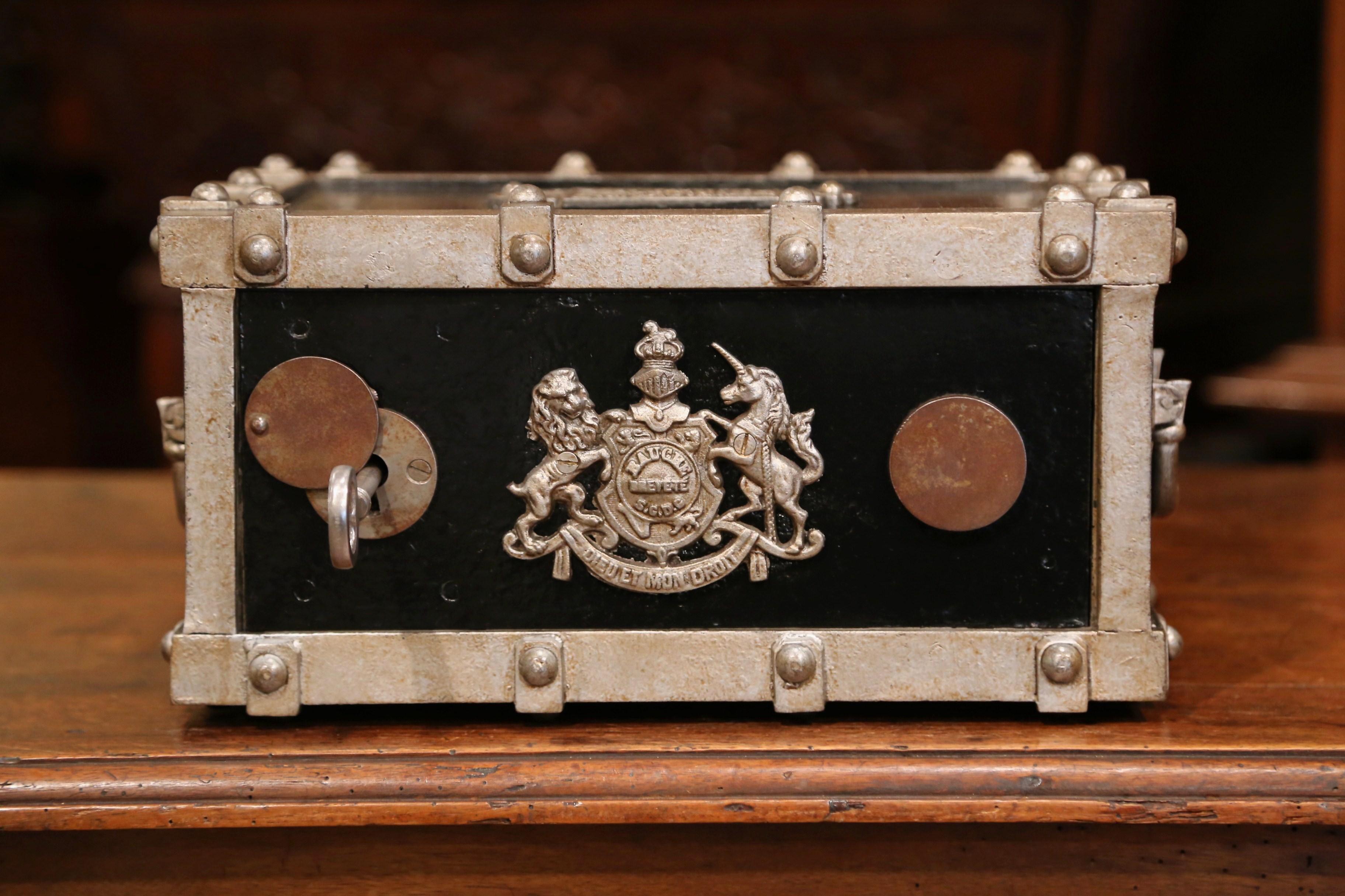 Keep your jewelry or important documents locked up in this fine, antique safe from the Champagne-Ardenne region of France. Crafted, circa 1870, the safe is cast iron and has a chic two-tone black and silver paint finish. The travel safe has two