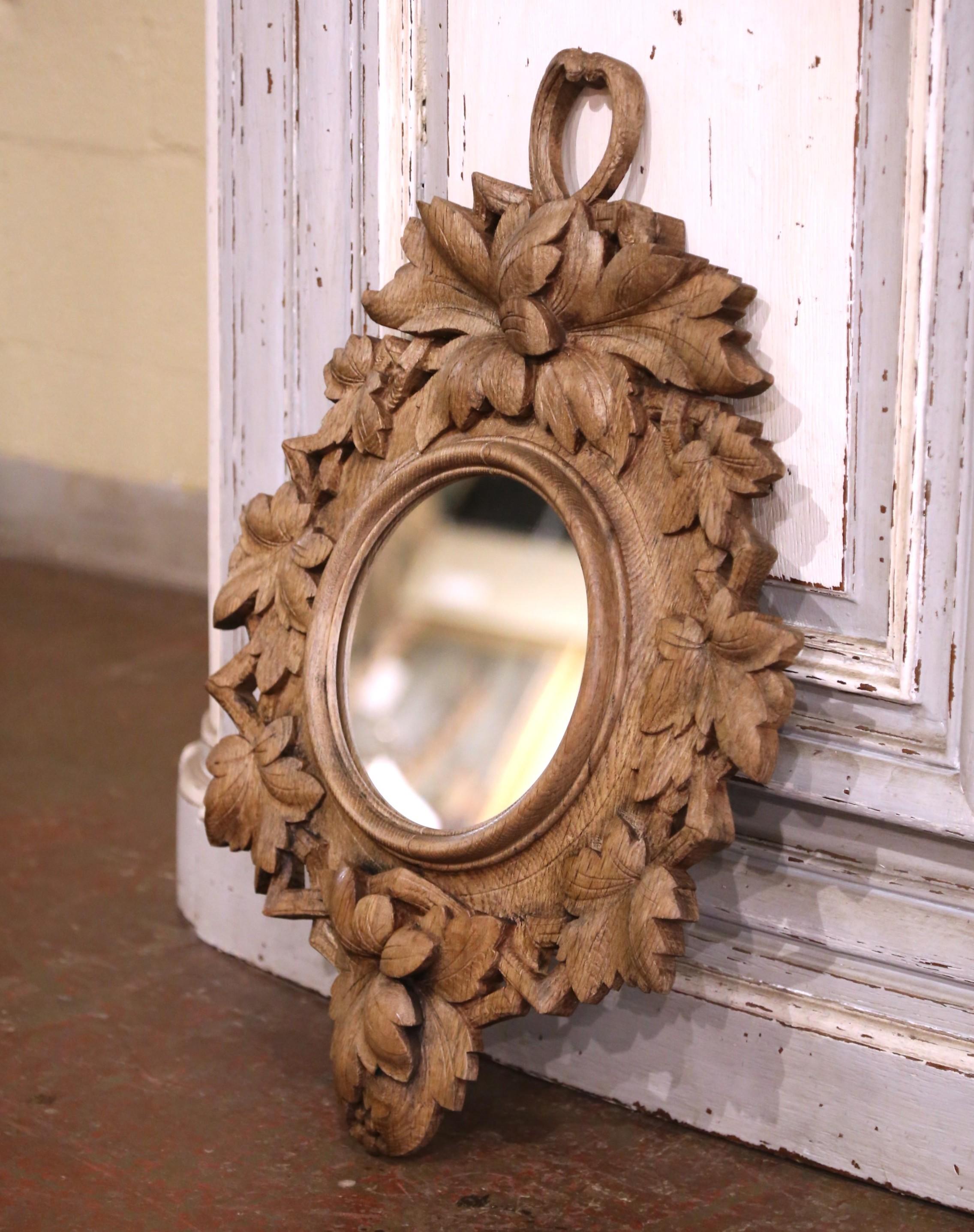 Decora una toilette, uno studio o un corridoio con questo specchio antico pesantemente intagliato. Creata in Francia intorno al 1880 e intagliata in Oak, la cornice Black Forest presenta un nodo di rami d'albero sul frontone circondato da motivi di