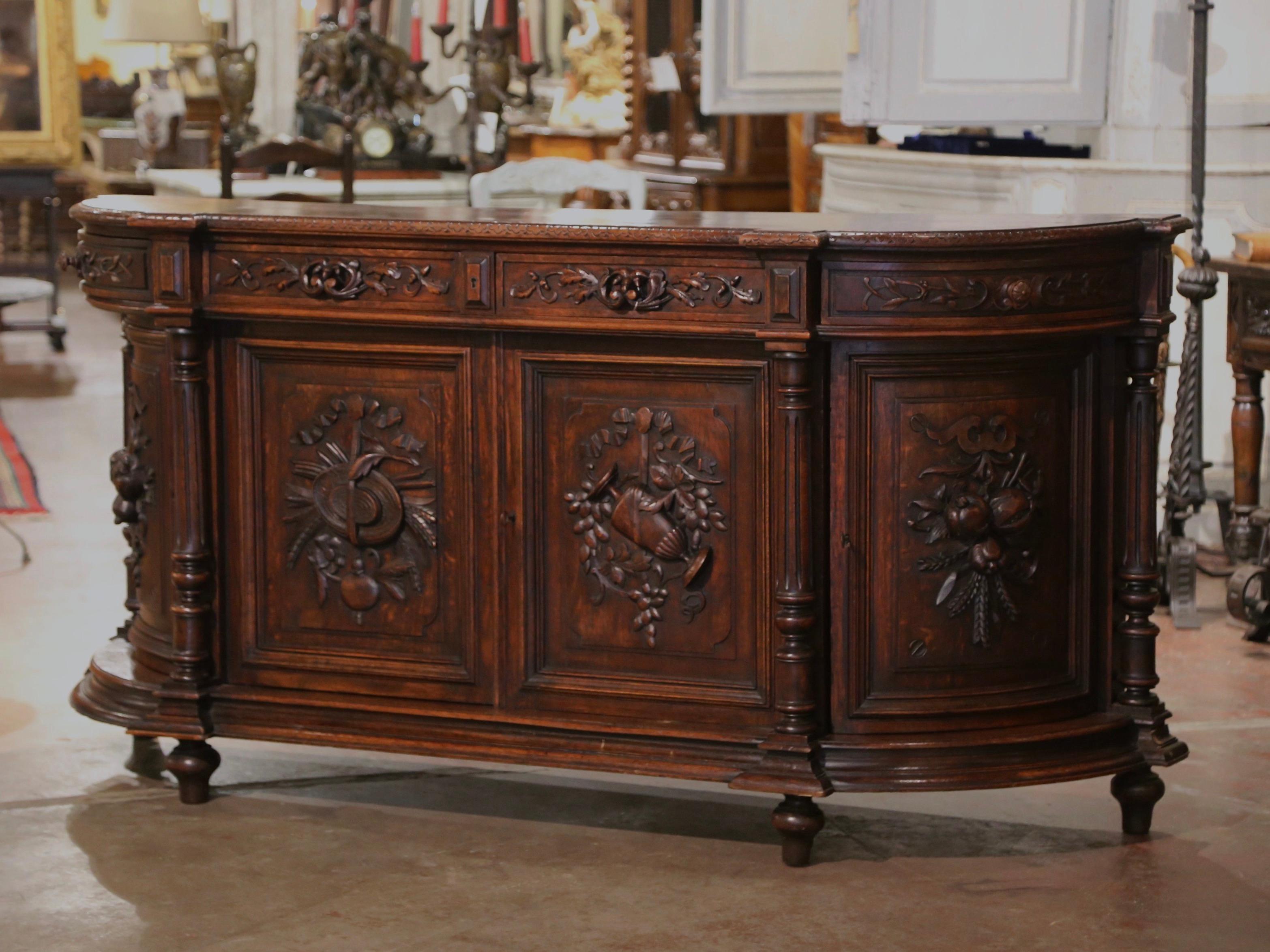 Decorate a ranch or hunting lodge with this important antique four-door sideboard. Crafted in France, circa 1870, the highly detailed buffet with curved sides stands on round feet over a wide bottom plinth. The long cabinet features four carved