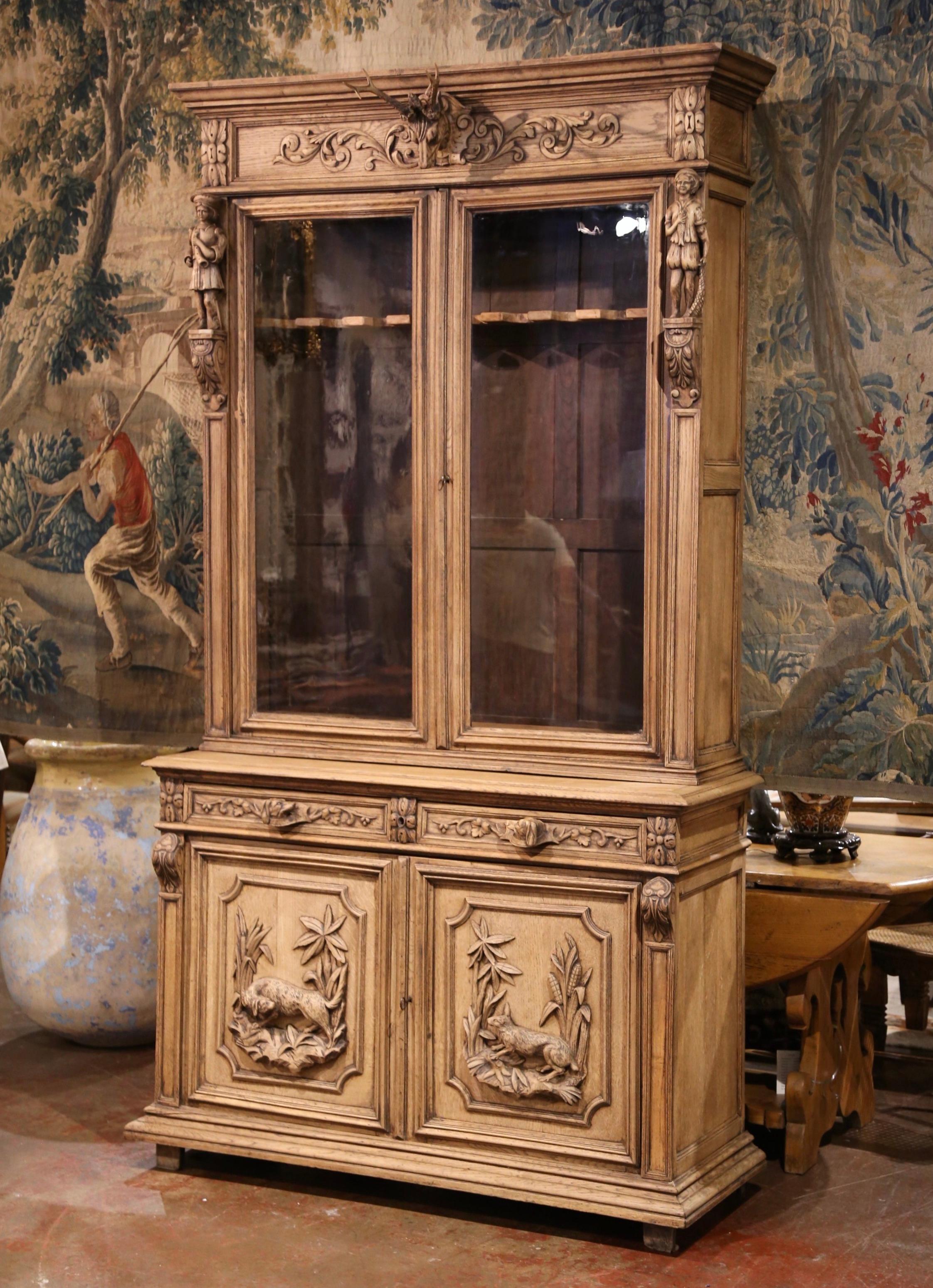 Display your rifle or shotgun collection in this beautifully carved, antique gun cabinet. Created in France, circa 1880, the important two-piece buffet with spline side columns, sits on square feet over a thick straight bottom plinth. The upper