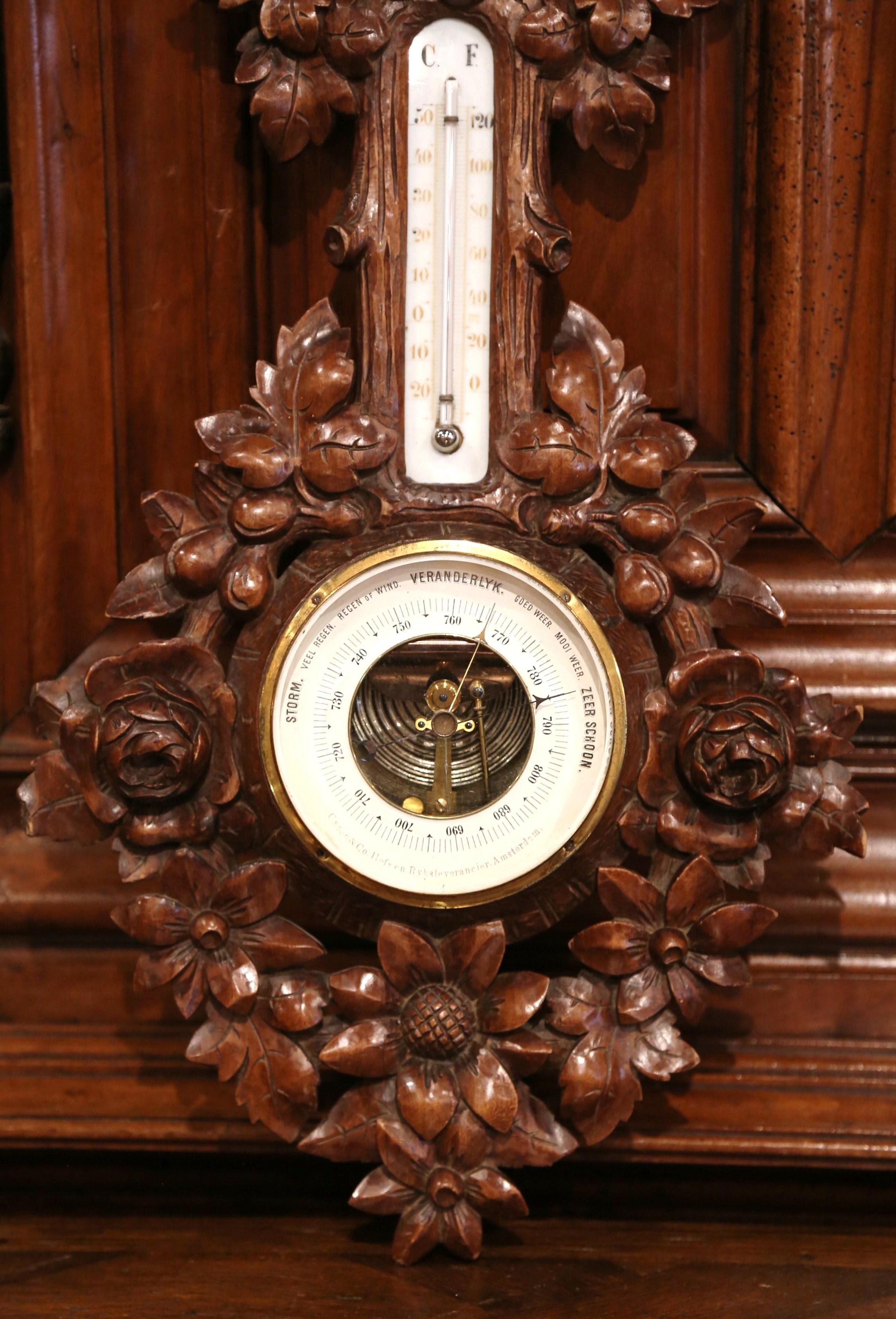 This elegant antique wall hanging barometer was crafted in France, circa 1880. The carved fruitwood weather and temperature reader features impressive, high-relief carved floral and leaf motifs. The thermometer with Celsius and Fahrenheit reading is