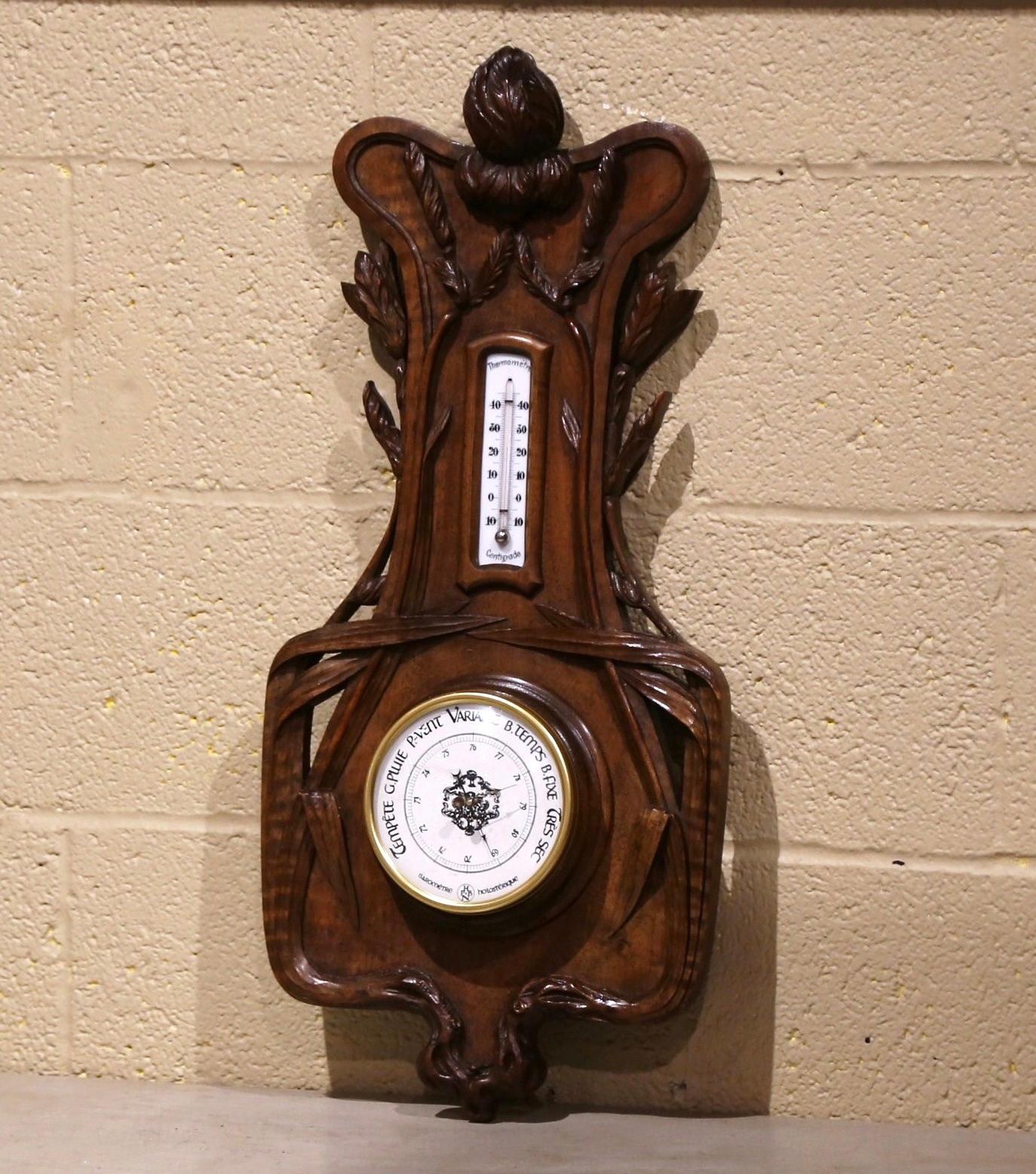 This elegant antique wall hanging barometer was crafted in France, circa 1880. The carved fruitwood weather and temperature reader features impressive, high-relief carvings of reed and leaf motifs throughout. The thermometer with Celsius and