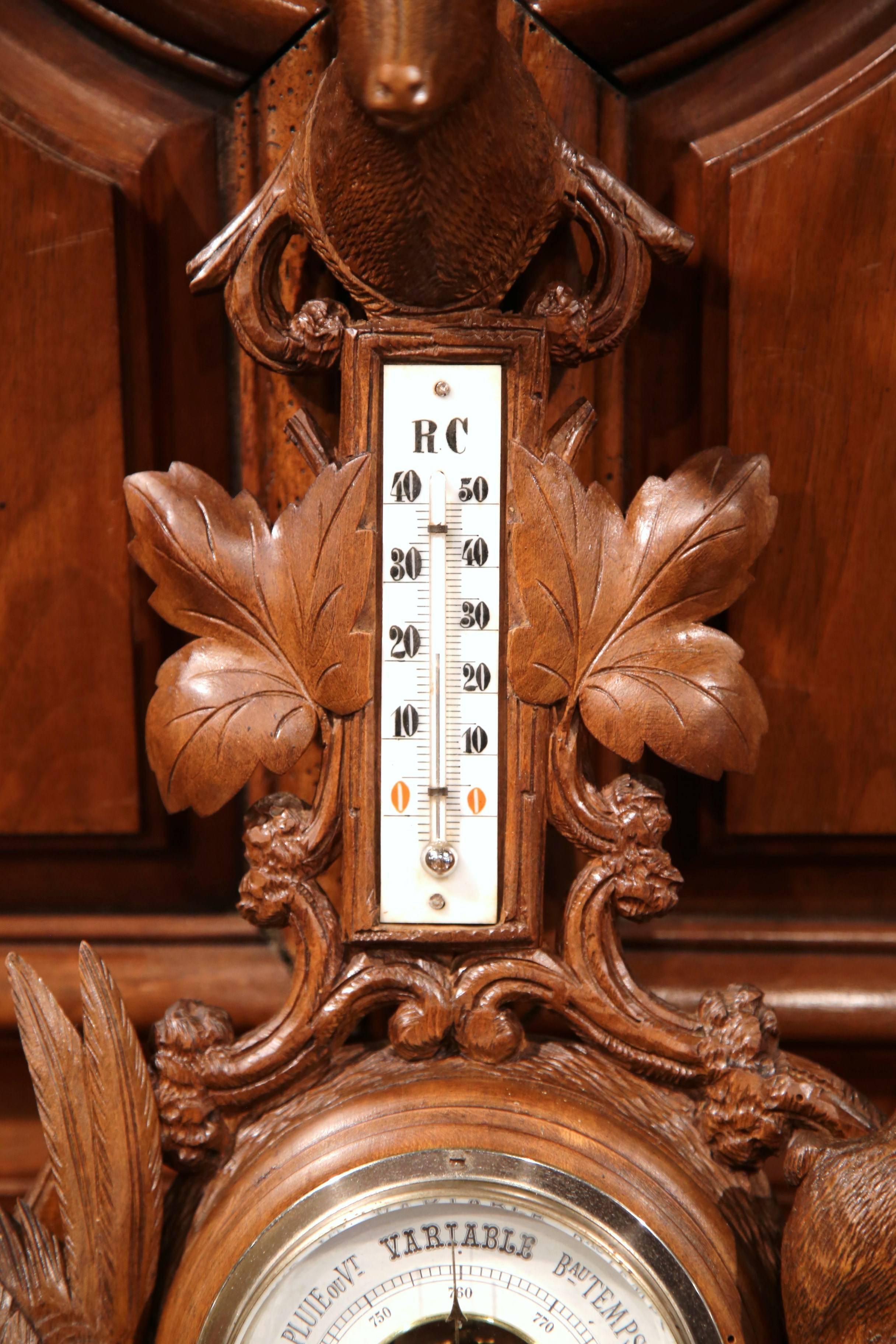 This elegant antique wall hanging barometer was crafted in France, circa 1880. The carved fruitwood weather and temperature reader features impressive, high-relief carvings, it has a carved deer with glass eyes at the top, flanked with bird and