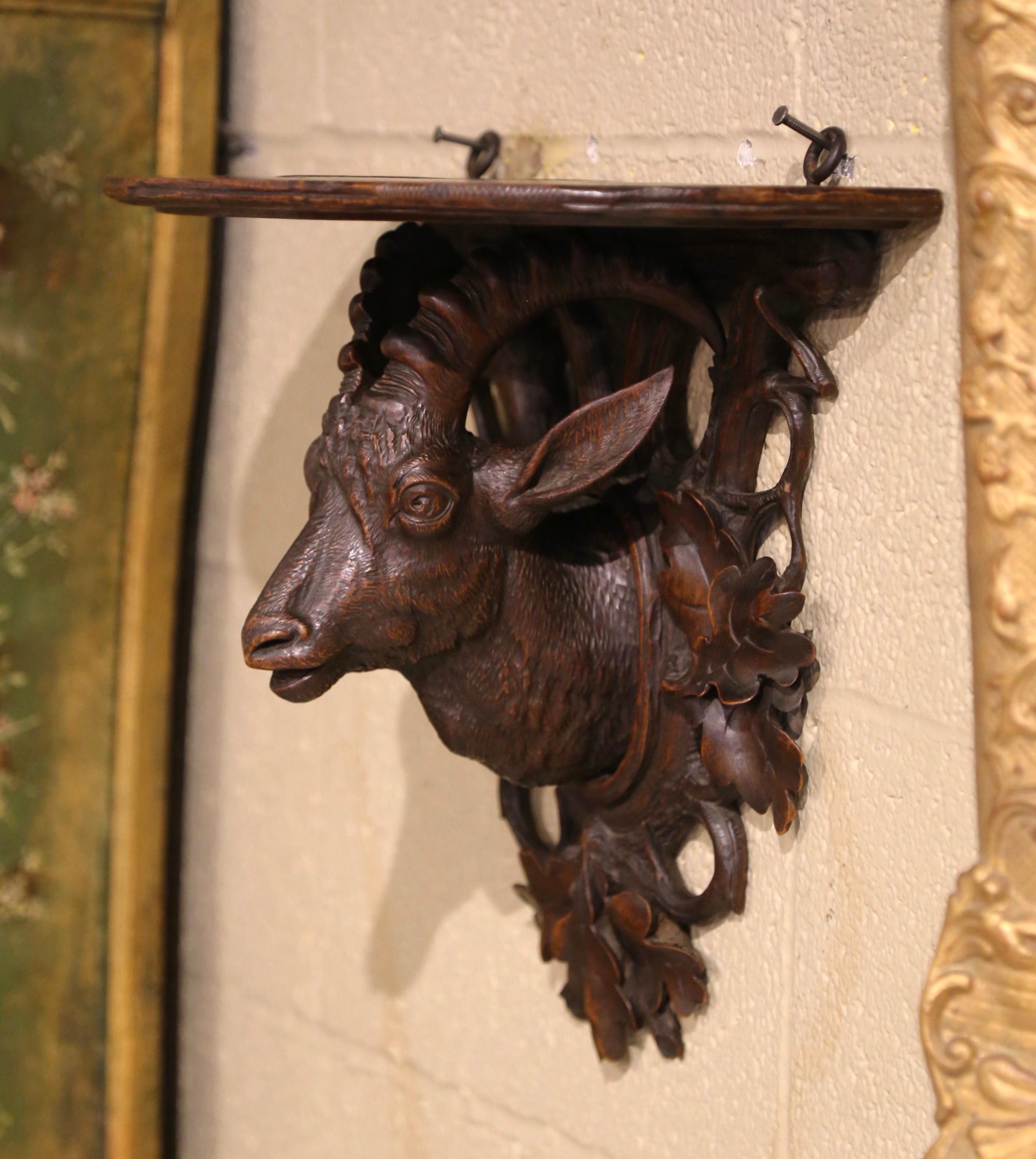 This beautifully antique wall bracket was carved in the Alps Mountains of France, circa 1870. Half circle in shape, the fruitwood shelf console features fine hand carved nature motifs including a deer figure, foliage and tree branches. The corbel