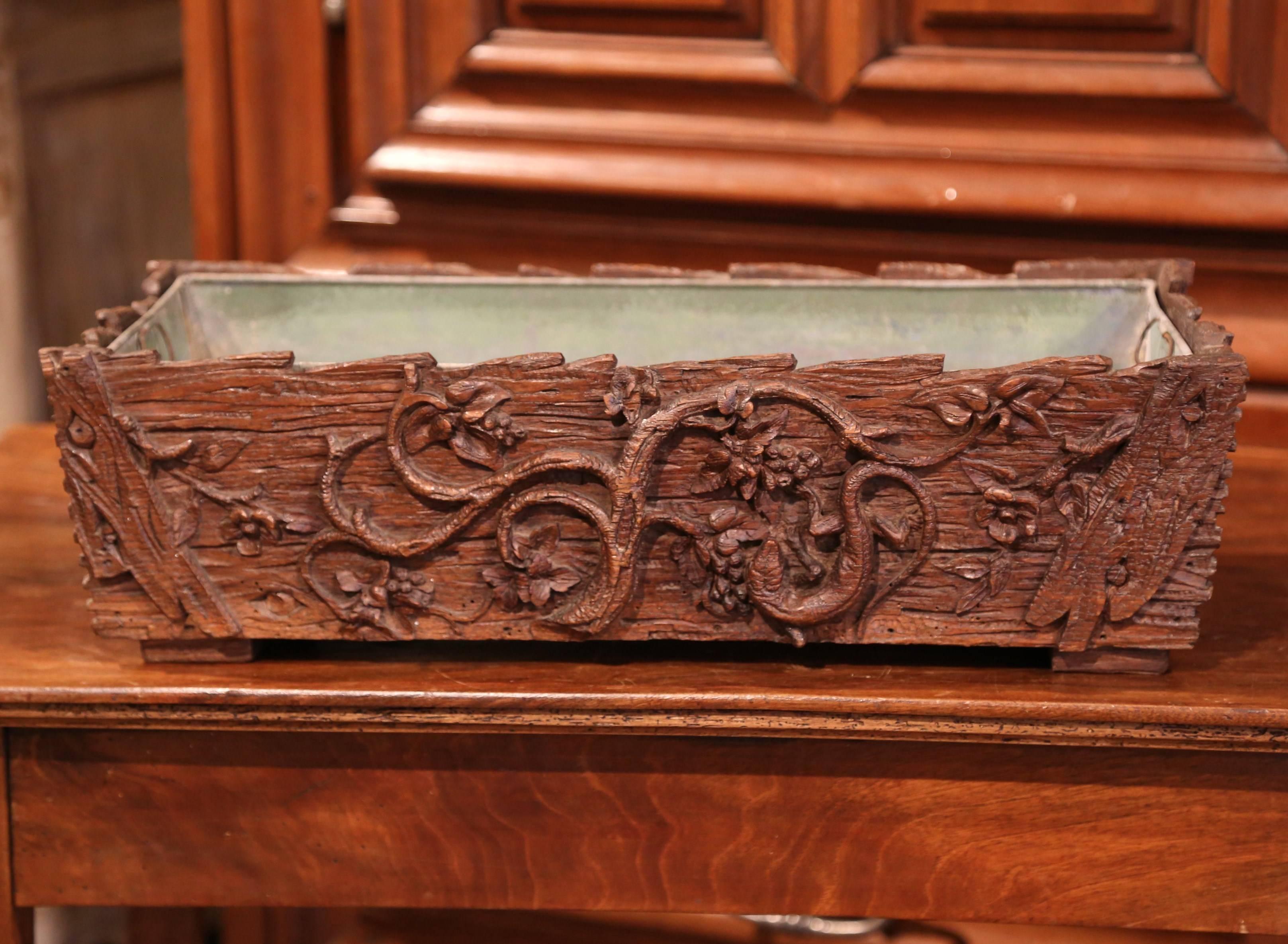 This beautiful, walnut, Black Forest jardinière carved as a wooden log was crafted in France, circa 1870. The rectangular fruitwood planter features hand carved floral, tree branches with leaf decor. The antique planter is in excellent condition,