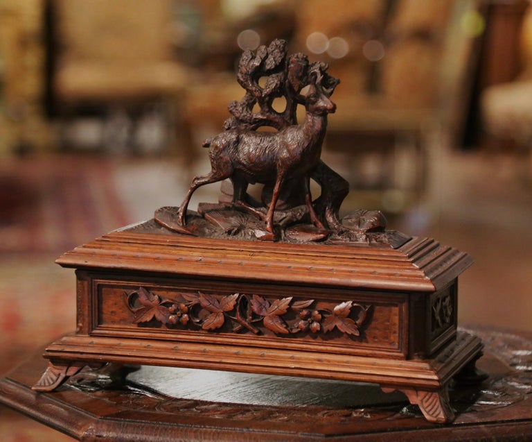 Place your jewelry and small valuable treasures in this beautifully carved decorative box. Carved of walnut wood in France circa 1880, the black forest box sits on small bracket feet and features high quality carving decor, including a deer on rocky